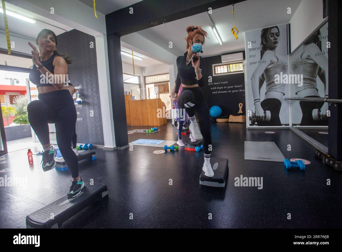 210405 -- NICOSIE, le 5 avril 2021 -- Un entraîneur portant un masque facial montre des exercices aux clients dans un gymnase rouvert à Nicosie, Chypre, le 5 avril 2021. L’entraînement sportif individuel a repris à Chypre depuis vendredi dernier. Jusqu'à sept personnes sont autorisées dans les gymnases et les piscines publiques. Photo de /Xinhua CYPRUS-NICOSIE-COVID-19-GYMS-ROUVRIR GeorgexChristophorou PUBLICATIONxNOTxINxCHN Banque D'Images