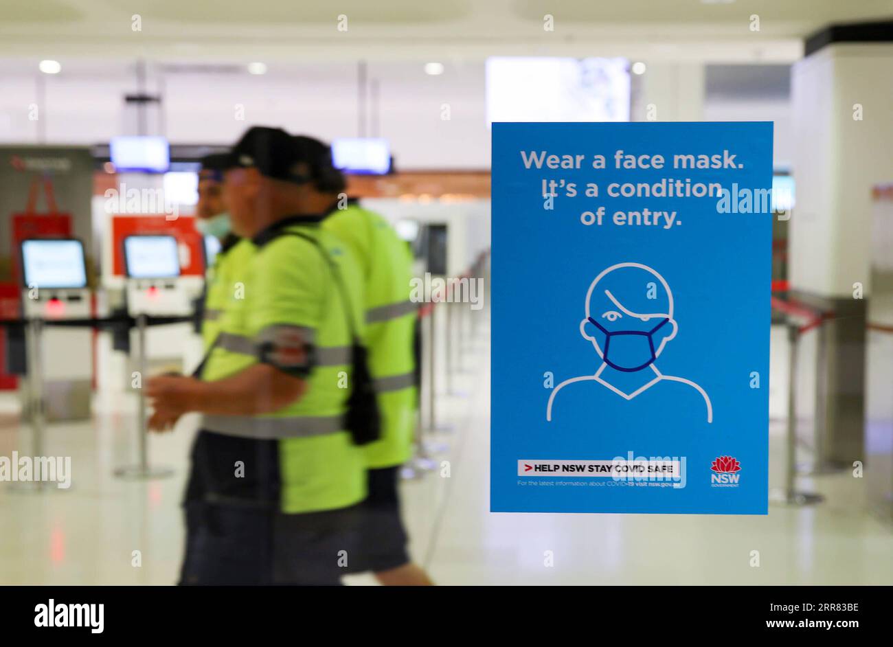 210415 -- SYDNEY, le 15 avril 2021 -- des travailleurs de l'aéroport passent devant un panneau d'affichage à l'aéroport de Sydney, à Sydney, en Australie, le 15 avril 2021. La compagnie aérienne nationale australienne Qantas parle des perspectives de plus de vols intérieurs et de la réouverture des routes internationales face à quelques conditions favorables. AUSTRALIE-SYDNEY-COMPAGNIE AÉRIENNE BaixXuefei PUBLICATIONxNOTxINxCHN Banque D'Images