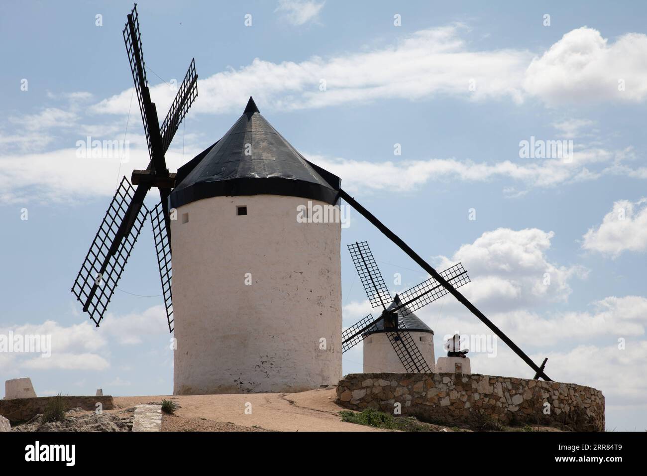 210417 -- CONSUEGRA, le 17 avril 2021 -- Une femme est assise devant des moulins à vent à Consuegra, en Espagne, sur Apirl 17, 2021. Le moulin à vent est l'un des paysages représentatifs de la région de Castille-la Manche en Espagne. ESPAGNE-CONSUEGRA-MOULIN MengxDingbo PUBLICATIONxNOTxINxCHN Banque D'Images