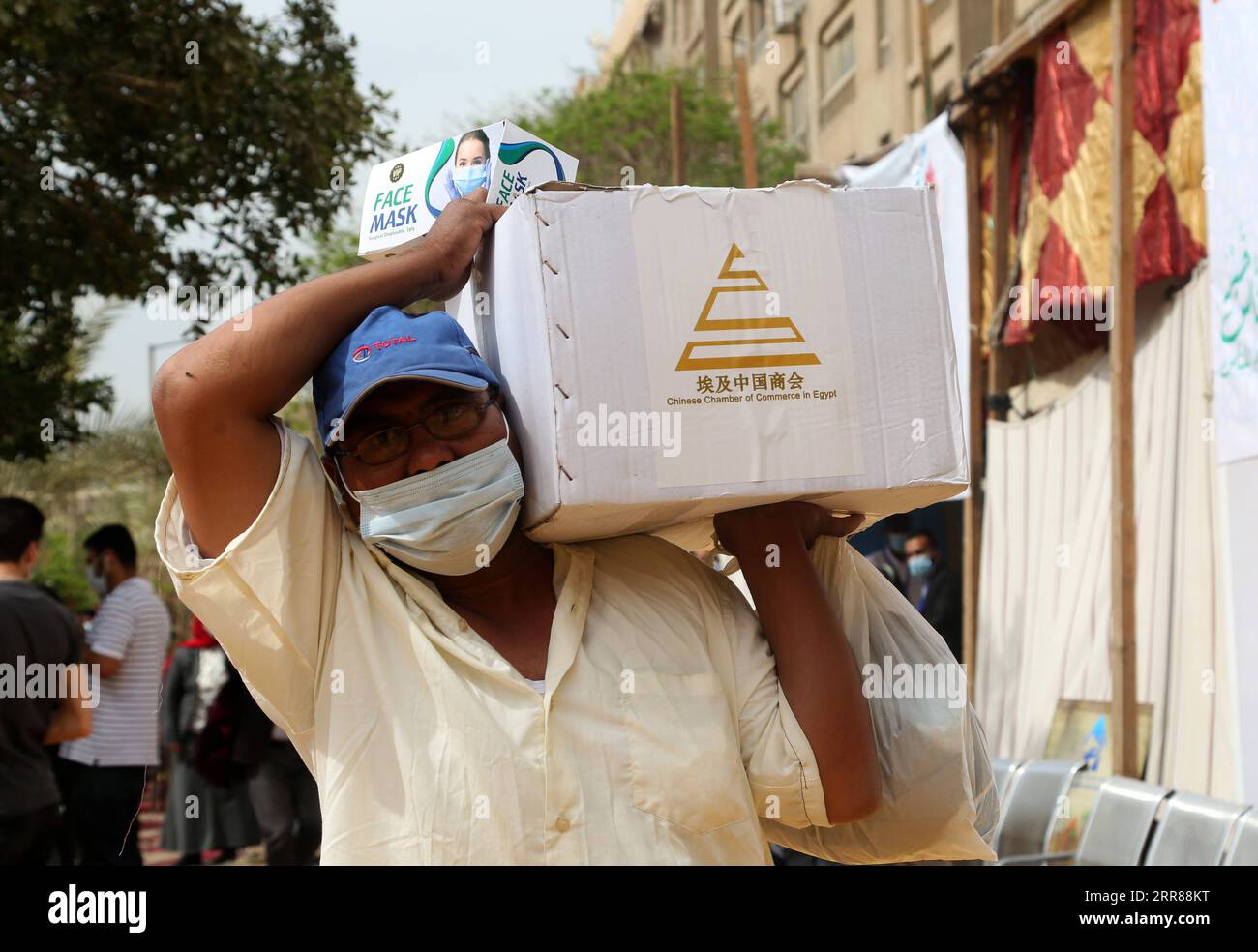 210424 -- LE CAIRE, le 24 avril 2021 -- un égyptien reçoit une boîte de nourriture donnée par la Chambre de commerce chinoise en Égypte lors d'un événement caritatif au Caire, en Égypte, le 24 avril 2021. Dans l’arrière-cour d’une organisation caritative égyptienne au Caire, des dizaines d’Égyptiens à faible revenu ont reçu samedi des boîtes de nourriture données par certaines entreprises chinoises opérant en Égypte. Photo de /Xinhua TO GO WITH Feature : les entreprises chinoises en Egypte font don de boîtes alimentaires aux pauvres pendant le Ramadan EGYPTE-CAIRE-ENTREPRISES CHINOISES-DONATION ALIMENTAIRE MohamedxAsad PUBLICATIONxNOTxINxCHN Banque D'Images