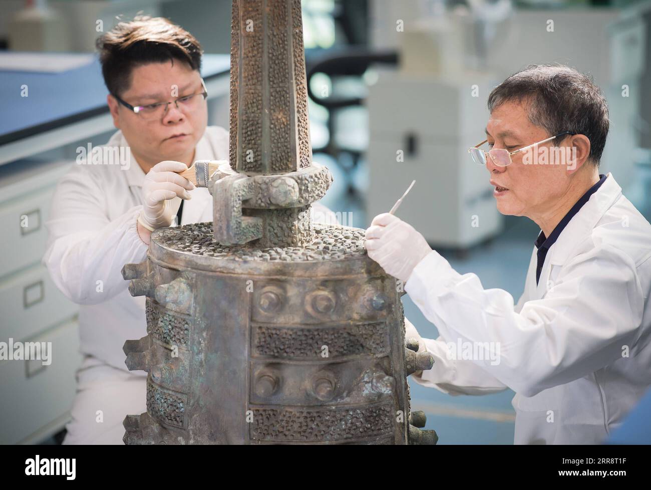 210517 -- WUHAN, 17 mai 2021 -- Fang Guorong R et son fils Fang Chen restaurent la cloche à carillon en bronze de Zenghouyu au musée provincial du Hubei, Wuhan, province du Hubei en Chine centrale, le 14 mai 2021. Dans le Centre de protection des reliques culturelles du Musée provincial du Hubei, Fang Guorong, 62 ans, et son fils Fang Chen, 33 ans, réparent la cloche en bronze de Zenghouyu depuis près de deux ans. Le travail de réparation est sur le point d'être terminé après une série de processus compliqués. Fang Guorong s'est engagé dans la restauration d'articles en bronze pendant plus de 40 ans depuis qu'il est entré au Musée provincial du Hubei à l'âge de Banque D'Images