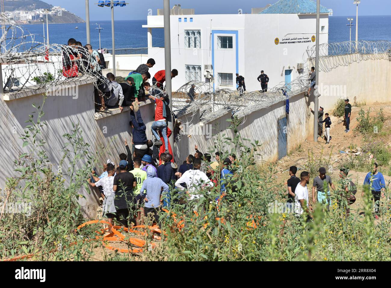 210519 -- FNIDEQ, le 19 mai 2021 -- des immigrants franchissent la barrière frontalière pour entrer dans l'enclave espagnole de Ceuta, à Fnideq, au Maroc, le 18 mai 2021. L'enclave espagnole de Ceuta doit faire face à un afflux d'immigrants après que quelque 6 000 personnes sont entrées sur le territoire en provenance du Maroc, selon la délégation du gouvernement central dans la ville. MAROC-FNIDEQ-ESPAGNE-IMMIGRANTS Xinhua PUBLICATIONxNOTxINxCHN Banque D'Images