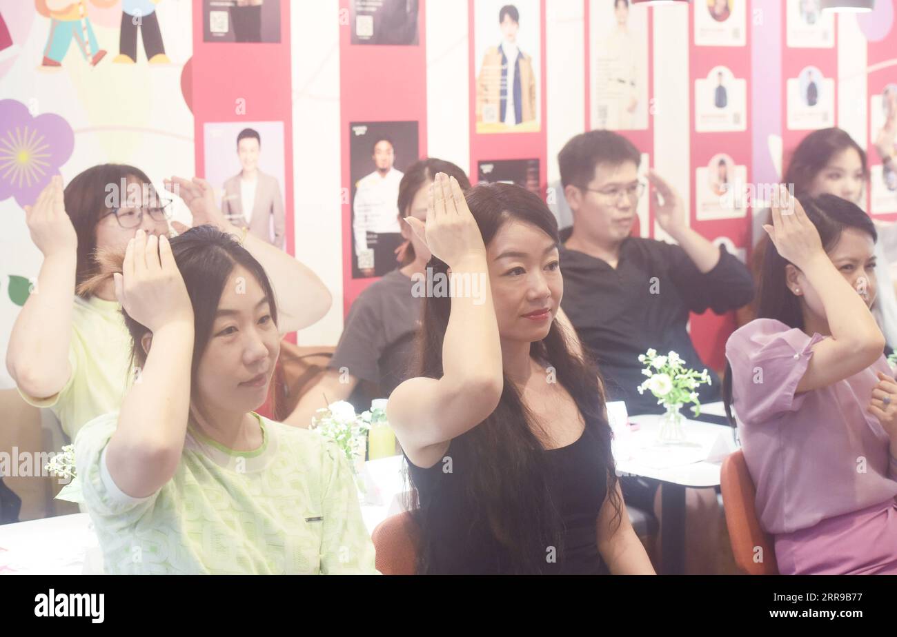 HANGZHOU, CHINE - 7 SEPTEMBRE 2023 - les citoyens apprennent la langue des signes 'Hangzhou vous accueille' dans un restaurant public à Hangzhou, province du Zhejiang, Chin Banque D'Images