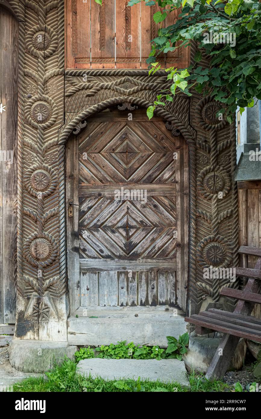 Les portes en bois sculptées avec soin continuent d'être une caractéristique de nombreuses maisons de village dans la région de Maramureș (Breb, Maramureș, Roumanie) Banque D'Images