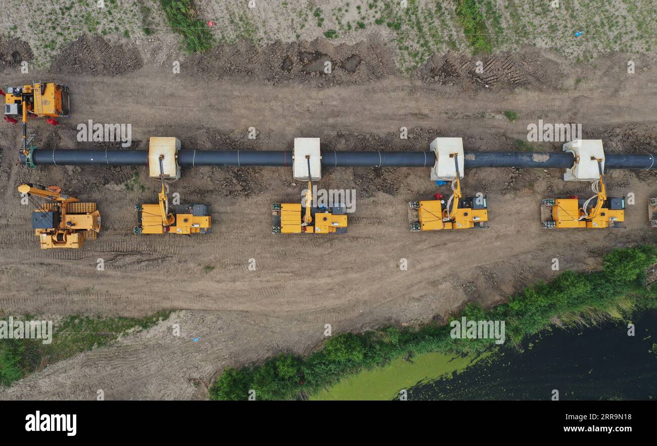 210624 -- TANGSHAN, 24 juin 2021 -- une photo aérienne prise le 24 juin 2021 montre des ouvriers installant des sections de tuyau sur un chantier de construction pour le pipeline sortant d'une station de réception de GNL de gaz naturel liquéfié, dans le canton de Wanglanzhuang, district de Fengnan, ville de Tangshan, province du Hebei, dans le nord de la Chine. Ce gazoduc de 176,18km, une fois terminé, devrait acheminer le gaz naturel de la station de réception de GNL de Xintian dans le district caofeidian de Tangshan vers le district de Baodi de Tianjin, également dans le nord de la Chine. CHINE-HEBEI-TANGSHAN-INSTALLATION DE GAZODUC CN YANGXSHIYAO PUBLICATIONXNOTXINXCHN Banque D'Images