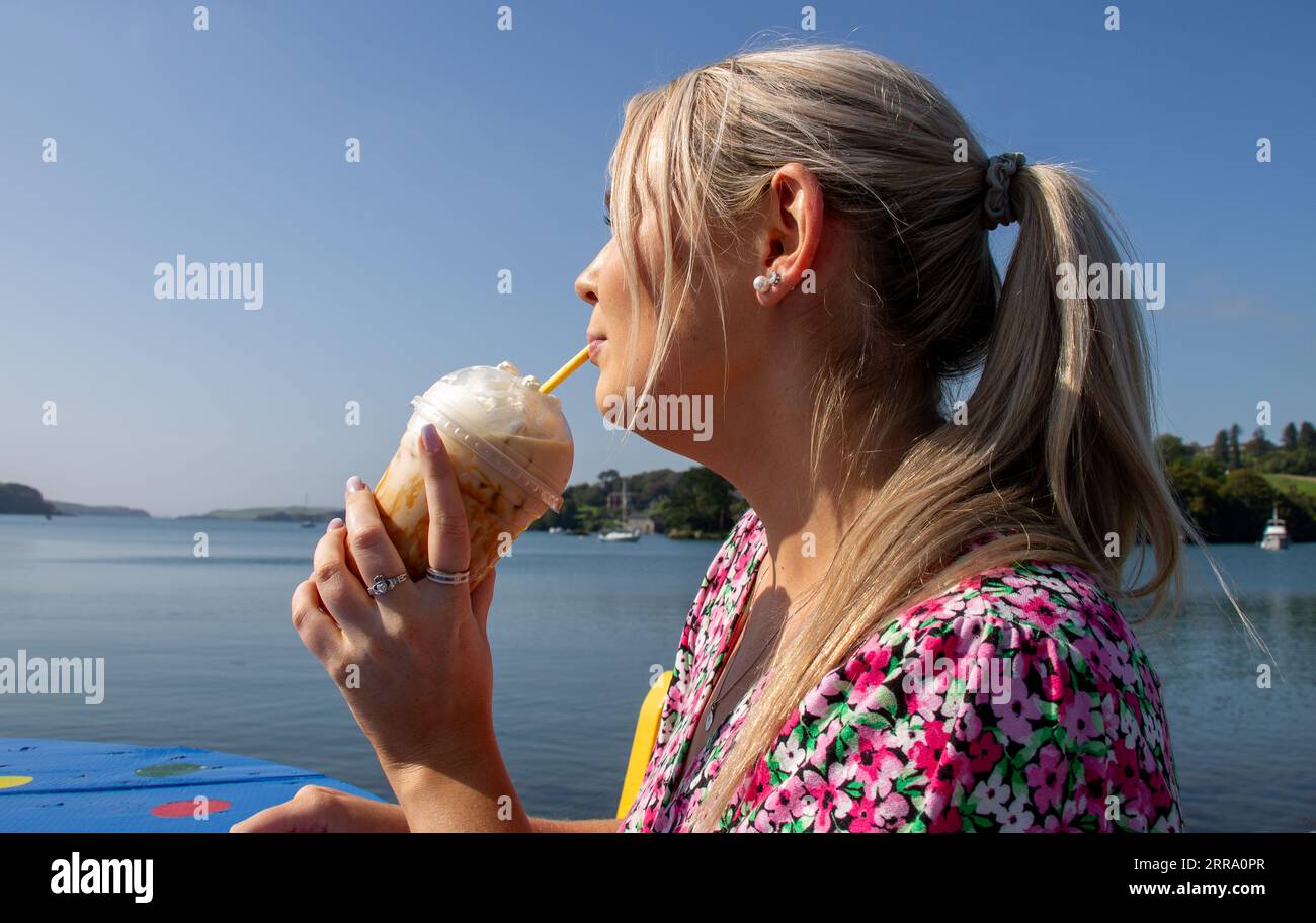 Jeune femme buvant du café caramel glacé le jour chaud d'été Banque D'Images