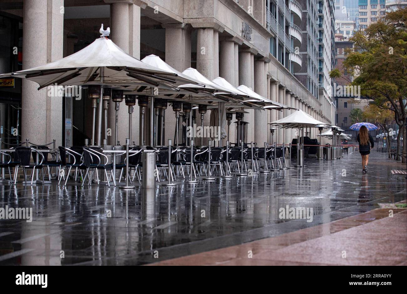 210709 -- SYDNEY, le 9 juillet 2021 -- Une femme passe devant une salle à manger vide à Sydney, en Australie, le 9 juillet 2021. L état de Nouvelle-Galles du Sud en Australie a annoncé vendredi un resserrement supplémentaire des restrictions sur le Grand Sydney et ses environs alors que l état continue de voir une augmentation quotidienne des cas de COVID-19. AUSTRALIE-SYDNEY-COVID-19-RESTRICTIONS-RESSERREMENT BaixXuefei PUBLICATIONxNOTxINxCHN Banque D'Images