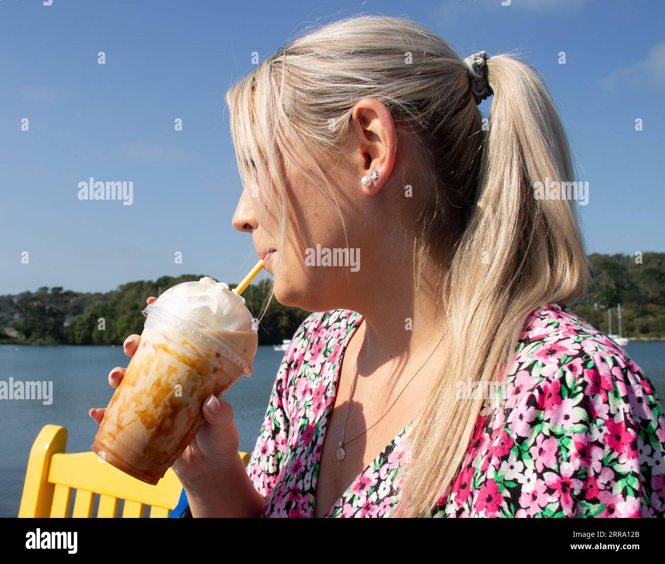 Jeune femme buvant du café caramel glacé le jour chaud d'été Banque D'Images