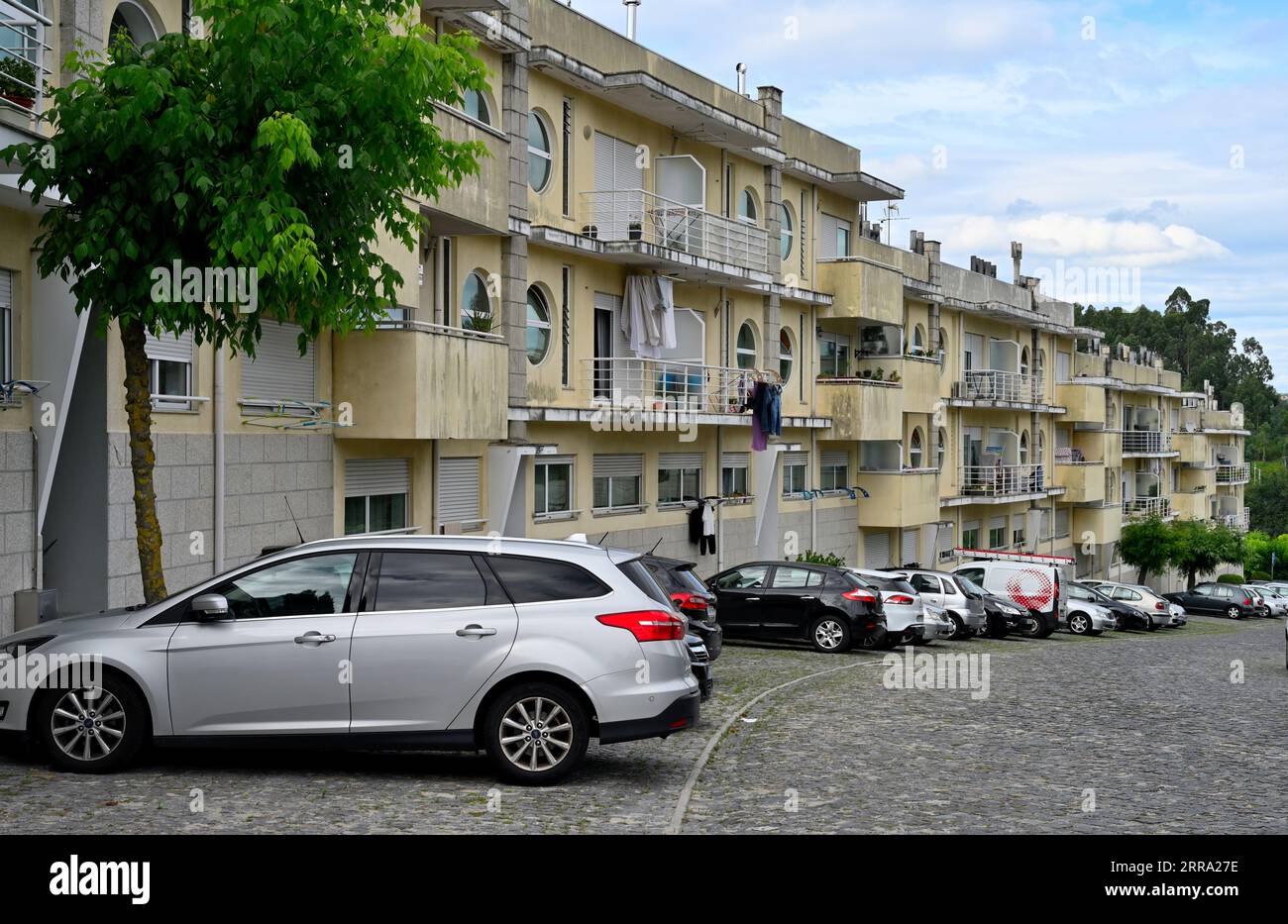 Terrasse rangée d'appartements avec balcons et voitures garées à l'extérieur, Agrola, Portugal Banque D'Images
