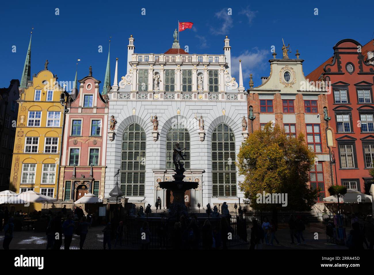 La vieille ville de Gdańsk en Pologne. Cour d'Artus (Dwór Artusa), fontaine de Neptune et maisons historiques avec pignons à long Market (Długi Targ). Banque D'Images