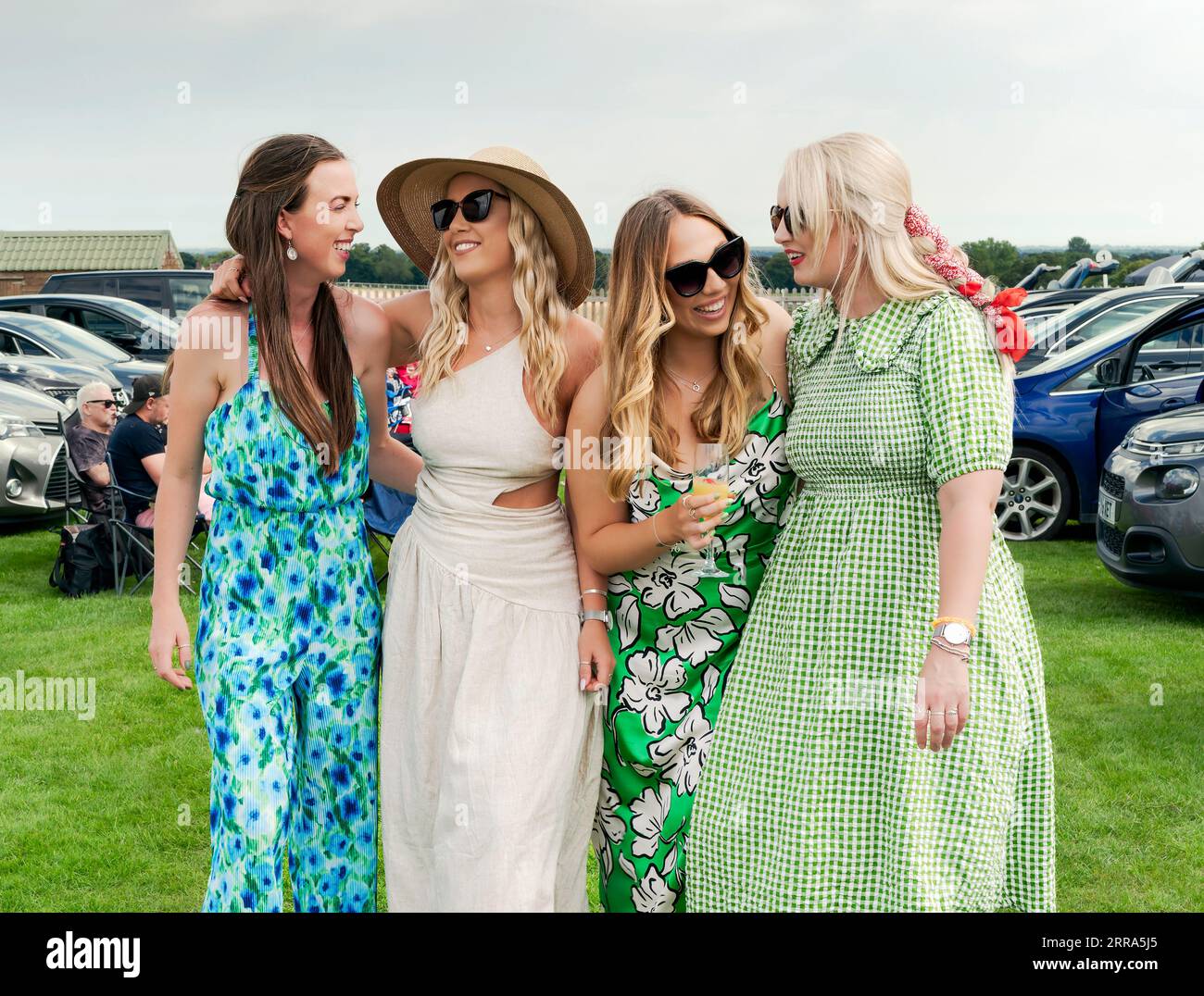 Un groupe de quatre femmes riant et souriant et vêtues de vêtements colorés profite de la Journée des dames aux courses à Beverley, au Royaume-Uni. Banque D'Images