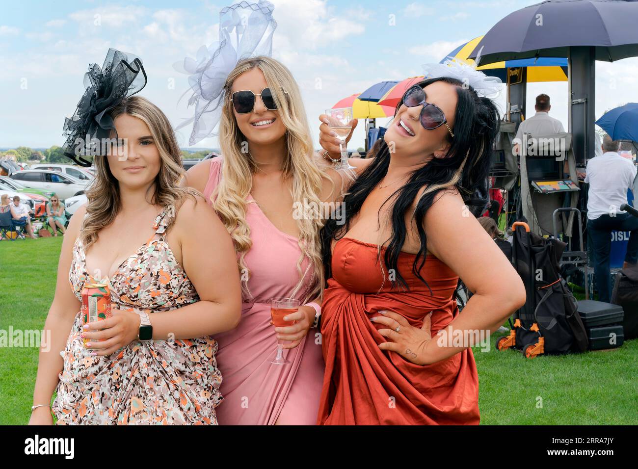 Un groupe de quatre femmes riant et souriant et vêtues de vêtements colorés profite de la Journée des dames aux courses à Beverley, au Royaume-Uni. Banque D'Images