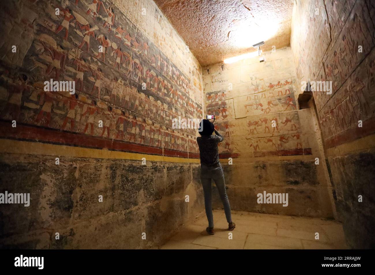 210804 -- LE CAIRE, le 4 août 2021 -- Un touriste visite une tombe officielle dans le district de Saqqara, au sud du Caire, Égypte, le 3 août 2021. La région de Saqarah, à environ 30 kilomètres au sud du Caire, abrite de nombreuses pyramides et un certain nombre de tombes de mastaba magnifiquement décorées, dans lesquelles de nombreuses peintures en relief colorées représentant la vie quotidienne de l'Egypte ancienne sont préservées. ÉGYPTE-SAQQARA-ANCIENNES TOMBES-RELIEFS PEINTURES SUIXXIANKAI PUBLICATIONXNOTXINXCHN Banque D'Images