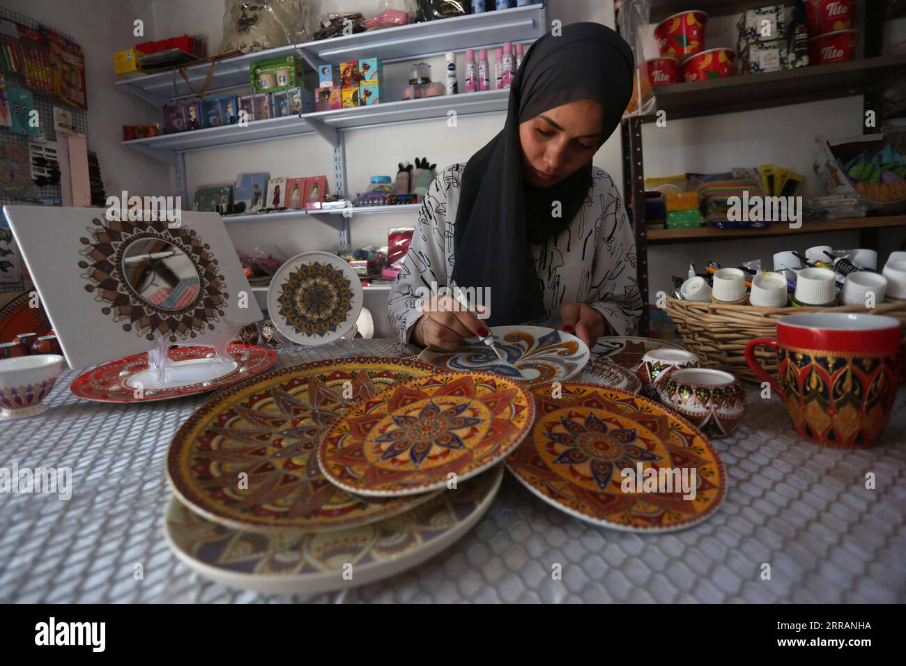 210810 -- JÉNINE, 10 août 2021 -- Diaa Sbehat décore une plaque de céramique avec des peintures de motifs islamiques dans son atelier de la ville de Jénine en Cisjordanie, le 10 août 2021. Sbehat était diplômée de l'Université ouverte Al-Quds avec un baccalauréat en technologie de l'information et de la communication avant de commencer à fabriquer des décorations en céramique. Elle gagne sa vie en vendant ses œuvres sur les réseaux sociaux. Photo de /Xinhua MIDEAST-JENIN-CERAMIC ART NidalxEshtayeh PUBLICATIONxNOTxINxCHN Banque D'Images