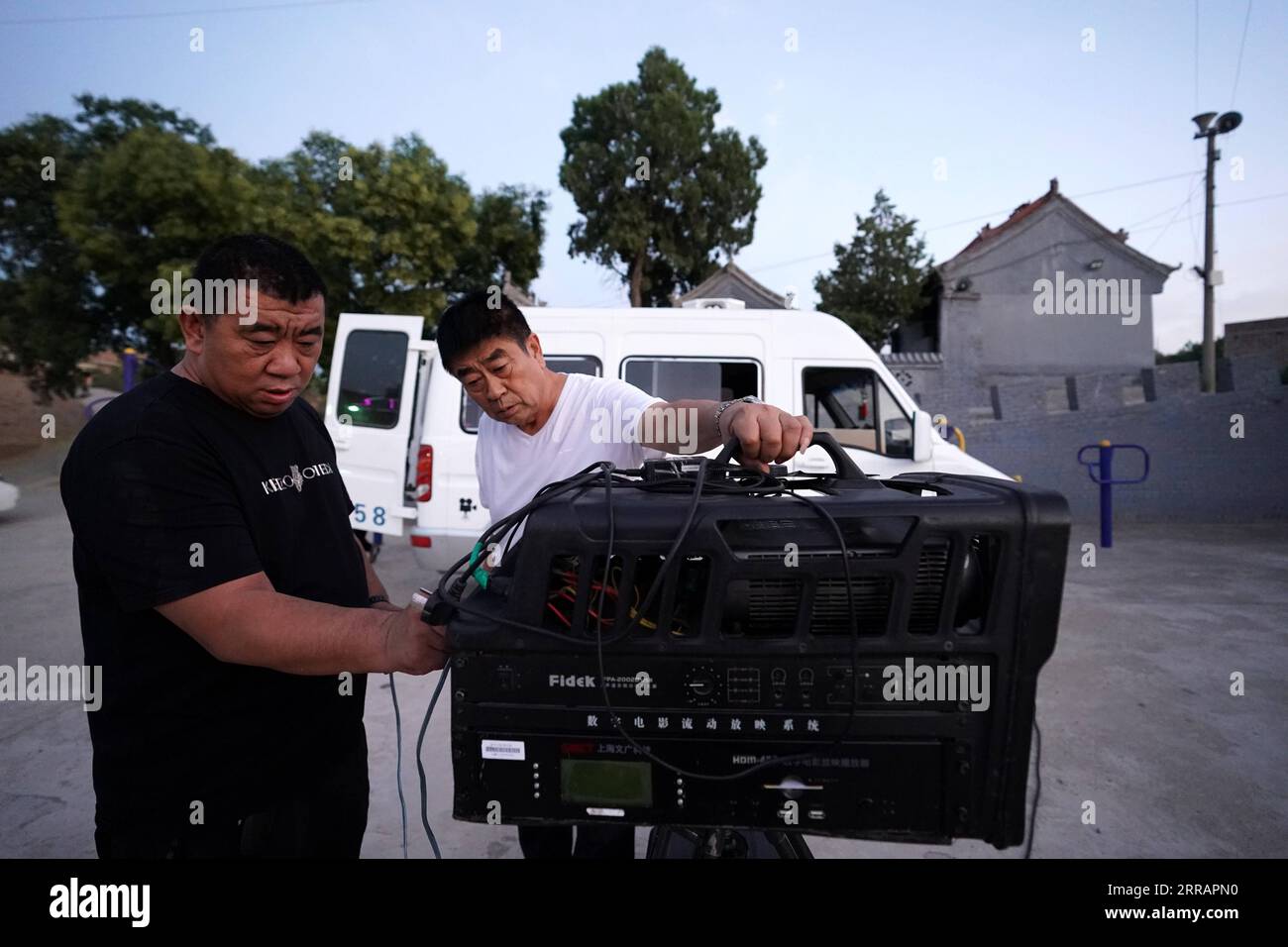 210813 -- TAIYUAN, 13 août 2021 -- Xue Xiaogang L se prépare à projeter un film au public dans le village de Gaojiayan, canton de Sanjiao dans le comté de Liulin, province du Shanxi du nord de la Chine, le 10 août 2021. En 1975, Sanjiao Township a créé une équipe de projection de films. Liu Bufei et Liu Dengzhao, tous deux cinéphiles depuis l'enfance, ont rejoint l'équipe et sont devenus projectionnistes ruraux. En 2007, l'équipe est devenue troïka avec le projectionniste de deuxième génération Xue Xiaogang, qui avait vu des films en plein air dans le village pendant son enfance. Au fil des ans, l'équipe de projection, pour d'innombrables fois a conduit al Banque D'Images