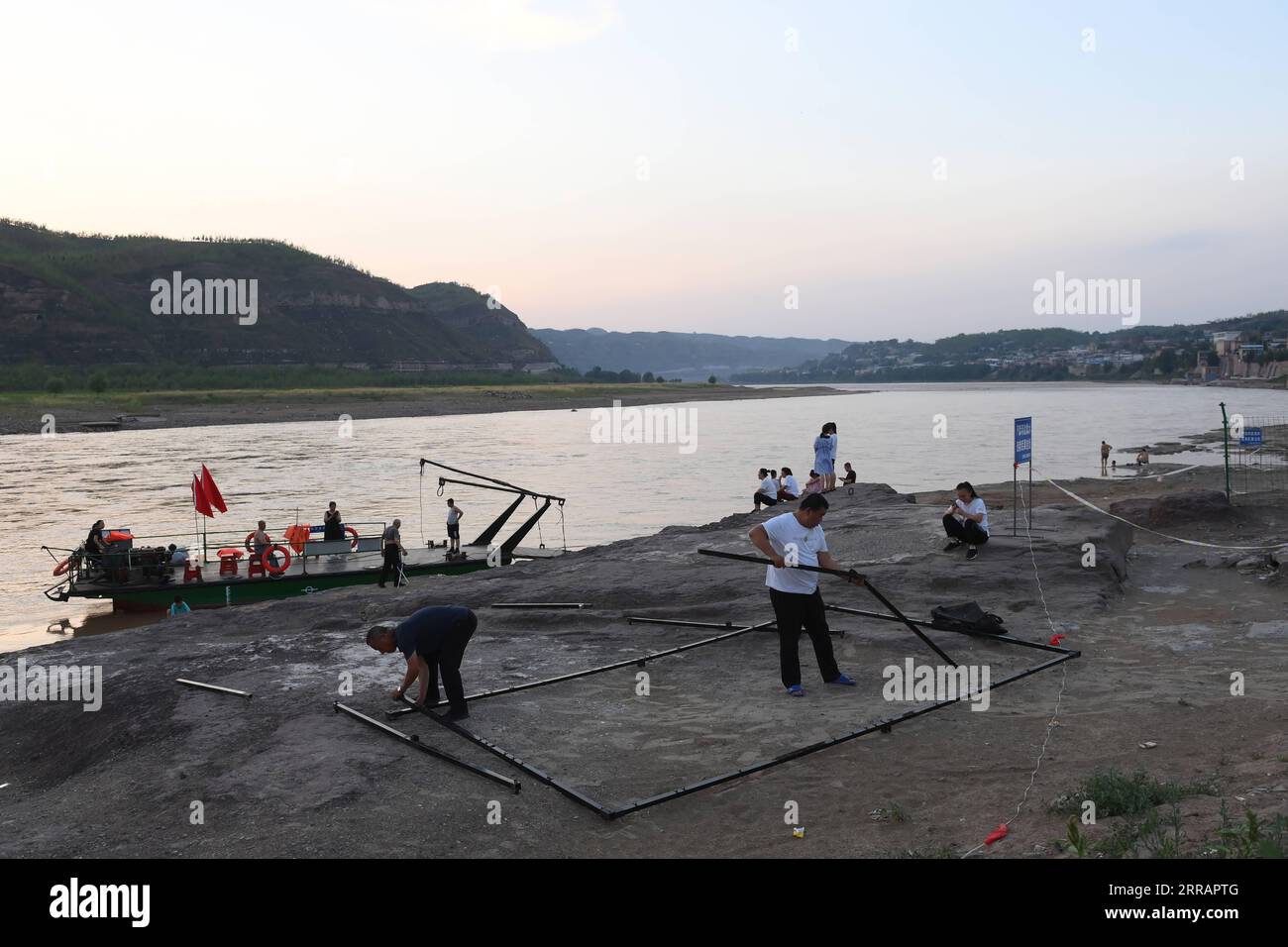 210813 -- TAIYUAN, 13 août 2021 -- des projectionistes ruraux ont installé des dispositifs de projection de films près du fleuve jaune dans le canton de Sanjiao, dans le comté de Liulin, province du Shanxi au nord de la Chine, le 14 juillet 2021. En 1975, Sanjiao Township a créé une équipe de projection de films. Liu Bufei et Liu Dengzhao, tous deux cinéphiles depuis l'enfance, ont rejoint l'équipe et sont devenus projectionnistes ruraux. En 2007, l'équipe est devenue troïka avec le projectionniste de deuxième génération Xue Xiaogang, qui avait vu des films en plein air dans le village pendant son enfance. Au fil des ans, l'équipe de projection, pour d'innombrables fois a conduit alo Banque D'Images