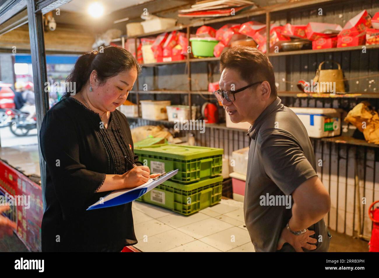 Chine, Überschwemmungen durch Starkregen à Chongqing 210830 -- CHONGQING, 30 août 2021 -- Un travailleur communautaire enregistre la perte d'un magasin lors de l'inondation dans le comté de Wuxi de Chongqing, dans le sud-ouest de la Chine, le 30 août 2021. De fortes pluies ont provoqué l'inondation de quatre rivières dans la municipalité de Chongqing, dans le sud-ouest de la Chine, et plus de 2 000 personnes ont été évacuées, selon le siège de la lutte contre les inondations et des secours en cas de sécheresse de Chongqing. Dans le comté de Wuxi, plus de 260 magasins ont été inondés en raison de pluies constantes. Les services locaux de sécurité publique et d'urgence ont mis en place conjointement des équipes de secours pour aider le sho Banque D'Images