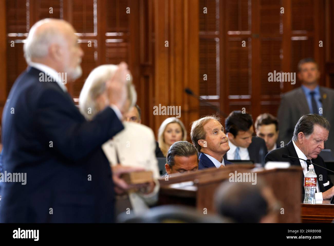 Le procureur général du Texas Ken Paxton regarde le sénateur du Texas Robert Nichols (à gauche), R-Jacksonville, assermenté au cours de la première journée du procès de destitution de Paxton dans les chambres du Sénat du Texas au Capitole de l’État du Texas à Austin le mardi 5 septembre 2023. Paxton est assis à côté des avocats Tony Buzbee (au centre à gauche) et Dan Cogdell (à droite). La Chambre du Texas, y compris une majorité de ses membres du GOP, a voté pour destituer Paxton pour corruption présumée en mai. (Juan Figueroa/Pool via le Dallas Morning News) Banque D'Images