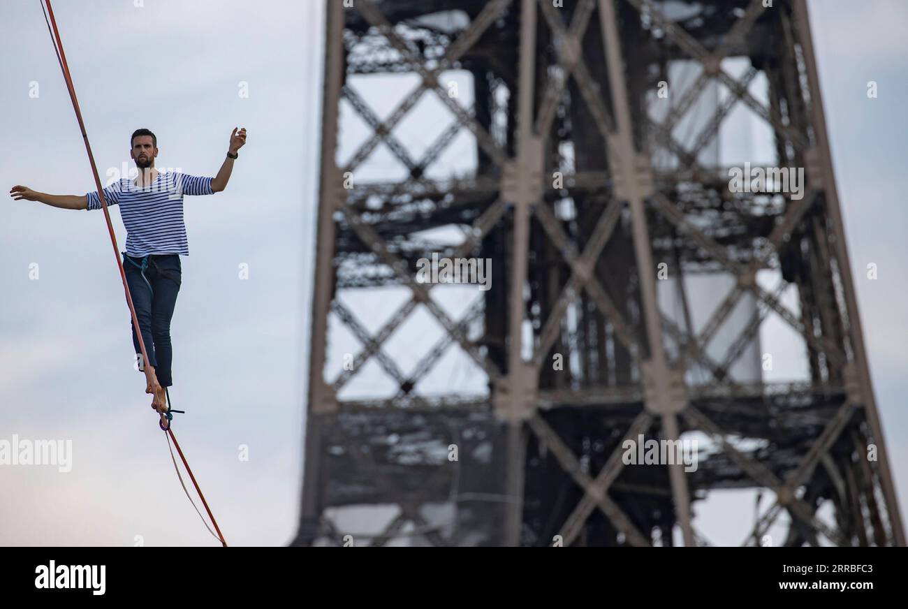 210918 -- PARIS, le 18 septembre 2021 -- le highliner français Nathan Paulin joue sur une slackline de 70 mètres de haut s'étendant sur 670 mètres entre la Tour Eiffel et le Théâtre National de Chaillot à Paris, France, le 18 septembre 2021. FRANCE-PARIS-TOUR EIFFEL-SLACKLINE-NATHAN PAULIN XINHUA PUBLICATIONXNOTXINXCHN Banque D'Images