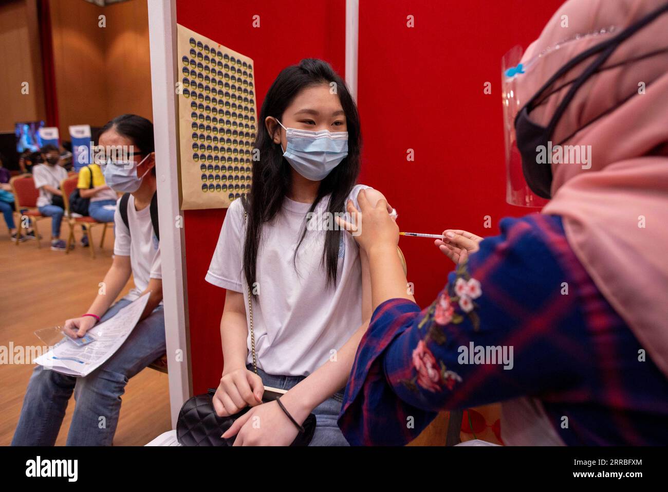 210920 -- KUALA LUMPUR, le 20 septembre 2021 -- Une fille reçoit une dose du vaccin COVID-19 alors que la Malaisie commence à déployer la vaccination pour les jeunes âgés de 12 à 17 ans, à Shah Alam, dans l'État de Selangor, en Malaisie, le 20 septembre 2021. La Malaisie a signalé 14 954 nouvelles infections COVID-19 à minuit dimanche, ce qui porte le total national à 2 097 830, selon le ministère de la Santé. Le pays a administré 219 081 doses de COVID-19 dimanche et environ 67,4 pour cent de la population a reçu au moins une dose et 56,5 pour cent sont entièrement vaccinés. Photo de /Xinhua MALAYSIA-SHAH ALAM-COVID-19-cas Banque D'Images