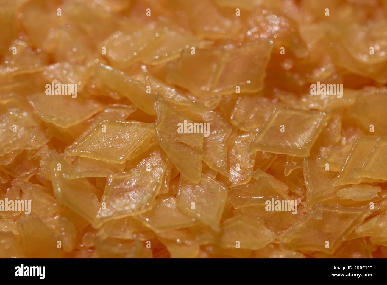 Détail des flocons de savon en forme de losange orange qui sont utilisés pour laver les vêtements dans la machine à laver automatique Banque D'Images
