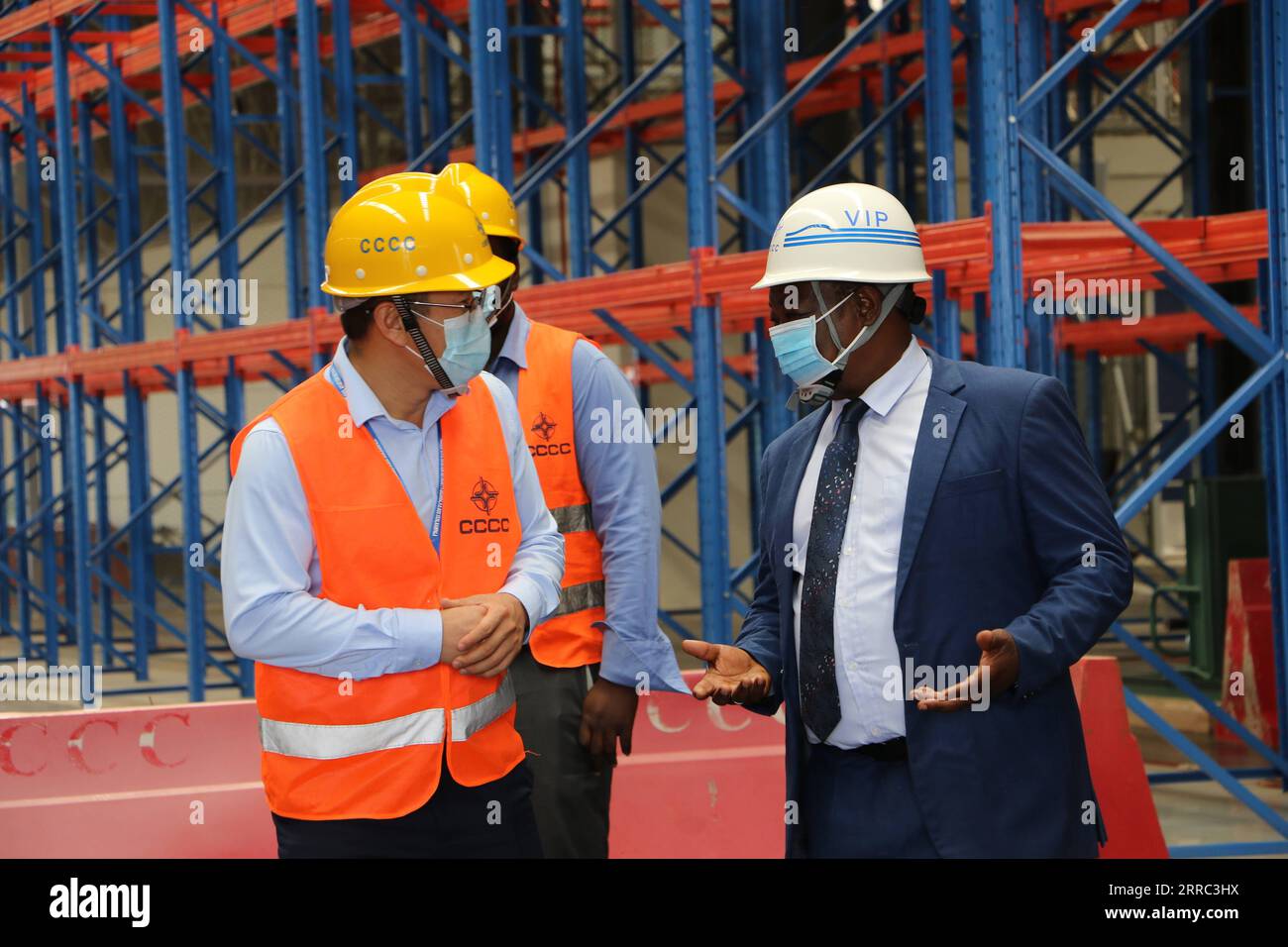 211015 -- ENTEBBE OUGANDA, 15 octobre 2021 -- Li Qinpu L, Front, un chef de projet de China Communications Construction Company CCCC, et Ayub Sooma R, Front, directeur des aéroports et de la sécurité aérienne à l'Autorité ougandaise de l'aviation civile, parlent au centre de fret nouvellement construit de l'aéroport international d'Entebbe à Entebbe, Ouganda, le 6 octobre 2021. Sur le tarmac de l'aéroport international d'Entebbe en Ouganda, sur les rives du lac Victoria, les techniciens chinois et leurs homologues ougandais ont mis la dernière main aux aires de trafic pendant que les avions entrent et sortent. L’aéroport vieux de 70 ans, ouvert en 1951 par la BRI Banque D'Images