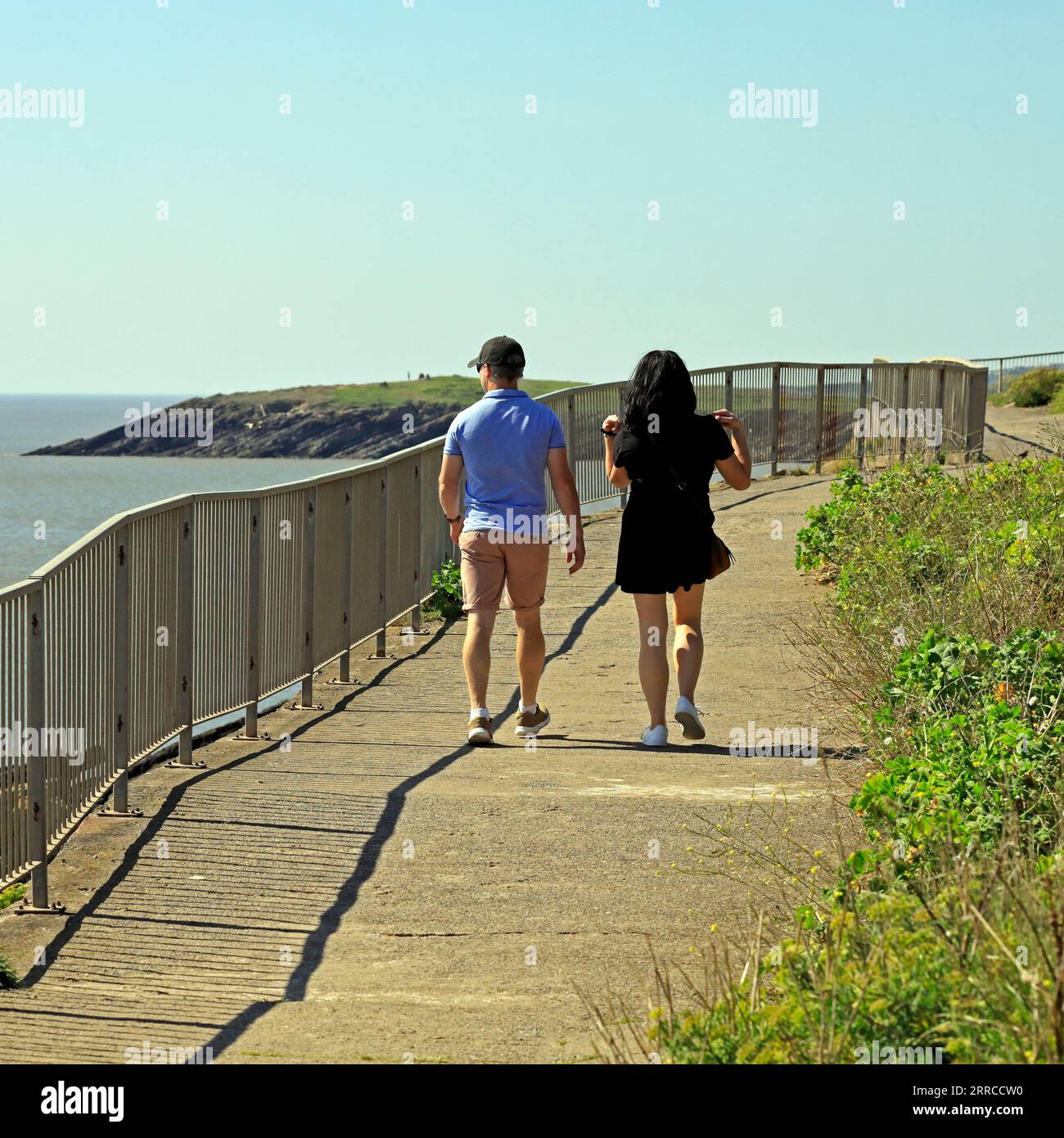 Un jeune couple se dirigeant vers Whitmore Bay depuis Jackson's Bay, le long du Wales Coastal Path, Barry Island, le jour le plus chaud de l'année. Sept. 2023. Été Banque D'Images