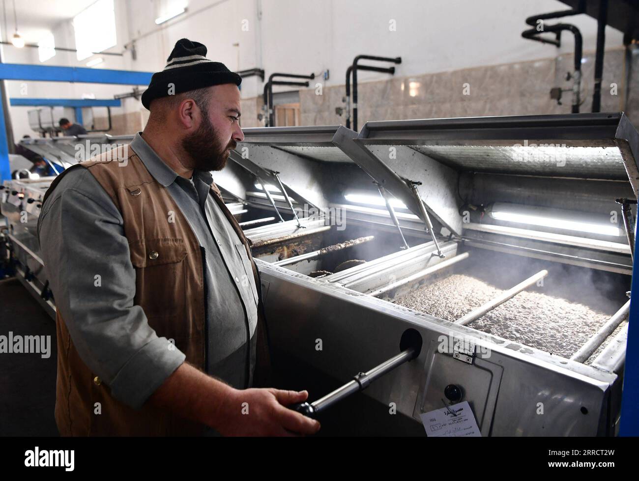 211116 -- HOMS SYRIE, 16 novembre 2021 -- Un ouvrier fait fonctionner une machine pour presser l'olive et extraire l'huile tout en laissant le grignon d'olive de côté pour un autre processus pour le faire combustible dans une usine de la province centrale de Homs, en Syrie, le 11 novembre 2021. Pendant les jours froids du dixième hiver de la guerre, le grignon d'olive est devenu le premier choix de beaucoup de Syriens pour le carburant de chauffage dans le contexte de la pénurie de gazole. Photo de /Xinhua TO GO WITH Feature : les Syriens choisissent de brûler du grignon d'olive pour se chauffer en raison de la pénurie de carburant SYRIA-HOMS-GRIGNON D'OLIVE-CHAUFFAGE FUEL AmmarxSafarjalani PUBLICATIONxNOTxINxCHN Banque D'Images