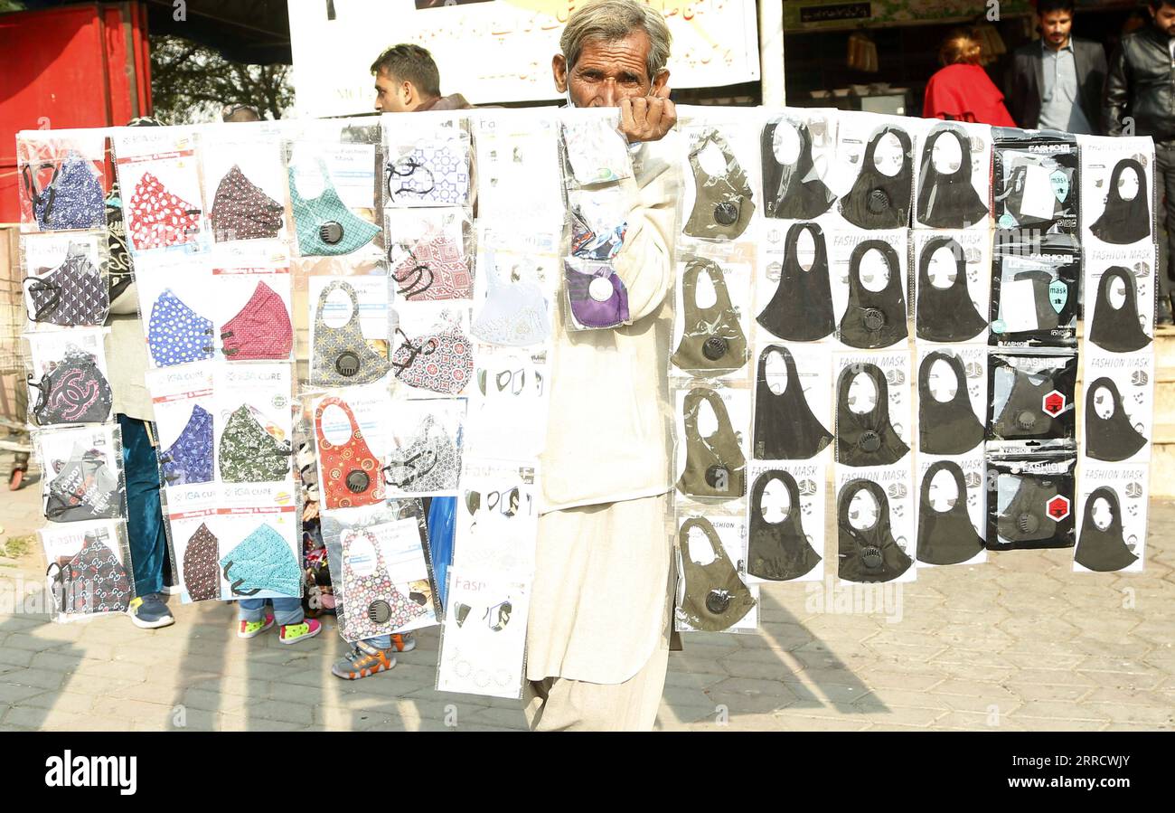 211119 -- ISLAMABAD, le 19 novembre 2021 -- Un homme vend des masques faciaux dans un marché d'Islamabad, Pakistan, le 16 novembre 2021. Le Pakistan a signalé moins de 300 cas quotidiens pendant plusieurs jours au cours de la dernière semaine, avec un taux de positivité tombant en dessous de 1 pour cent pendant un certain temps, selon le Centre national de commandement et d'opérations NCOC du Pakistan. Alors que le Pakistan a réussi à aplatir sa courbe COVID-19, le NCOC, qui supervise la réponse du Pakistan à la pandémie, a décidé d assouplir davantage les restrictions dans les villes en fonction de leurs taux de vaccination respectifs. POUR ALLER AVEC Feature : COVID-19 perd de la vitesse au Pakistan avec pragmati Banque D'Images