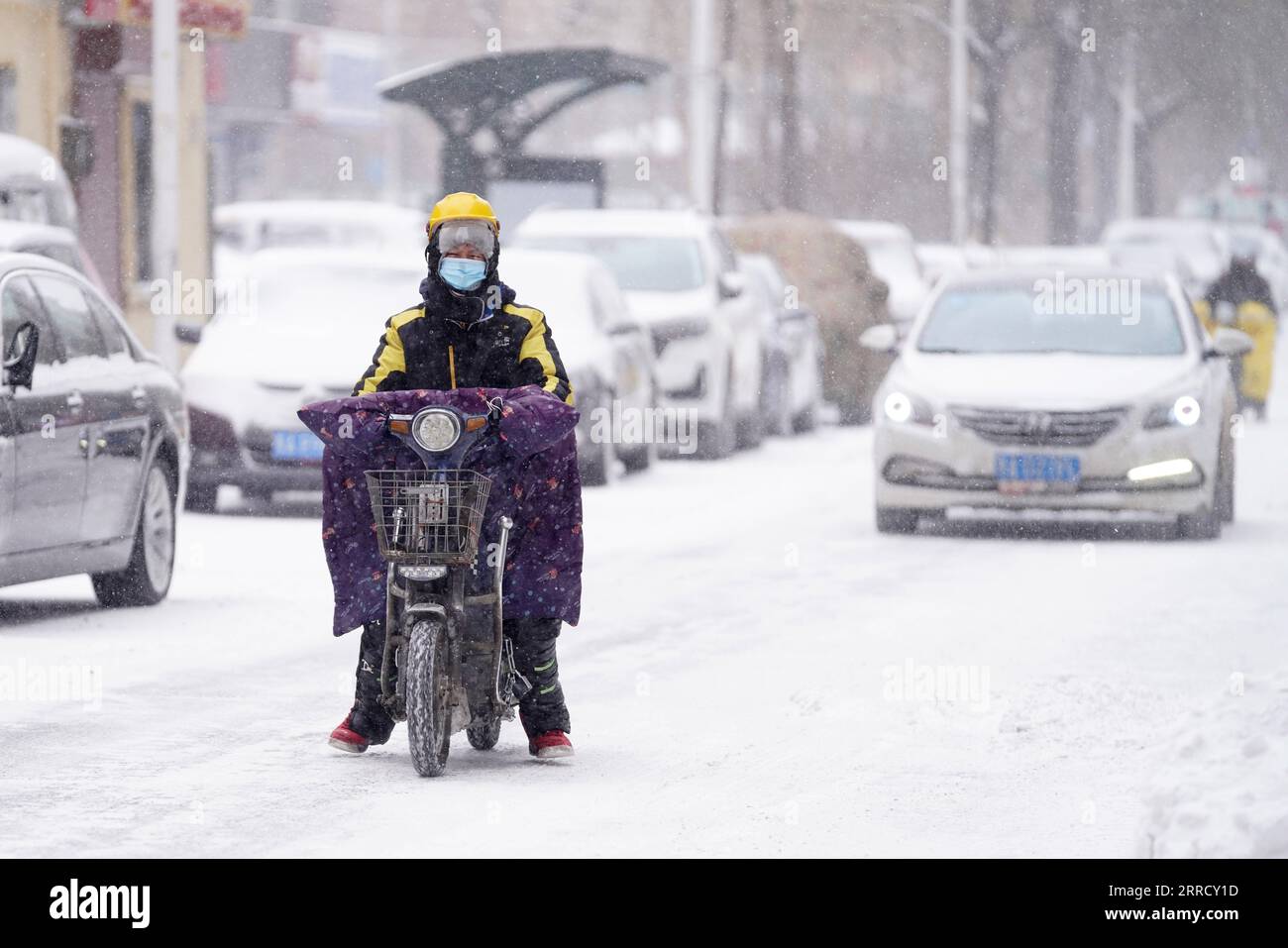 211122 -- HARBIN, le 22 novembre 2021 -- Un courrier se déplace dans une rue enneigée de Harbin City, dans la province du Heilongjiang, au nord-est de la Chine, le 22 novembre 2021. De fortes chutes de neige ont frappé de nombreuses régions du Heilongjiang récemment. Les membres du personnel de divers secteurs bravent les rafales glaciales et les flocons de neige pour assurer la disponibilité normale des services publics essentiels. CHINE-HEILONGJIANG-BLIZZARD CN WangxJianwei PUBLICATIONxNOTxINxCHN Banque D'Images