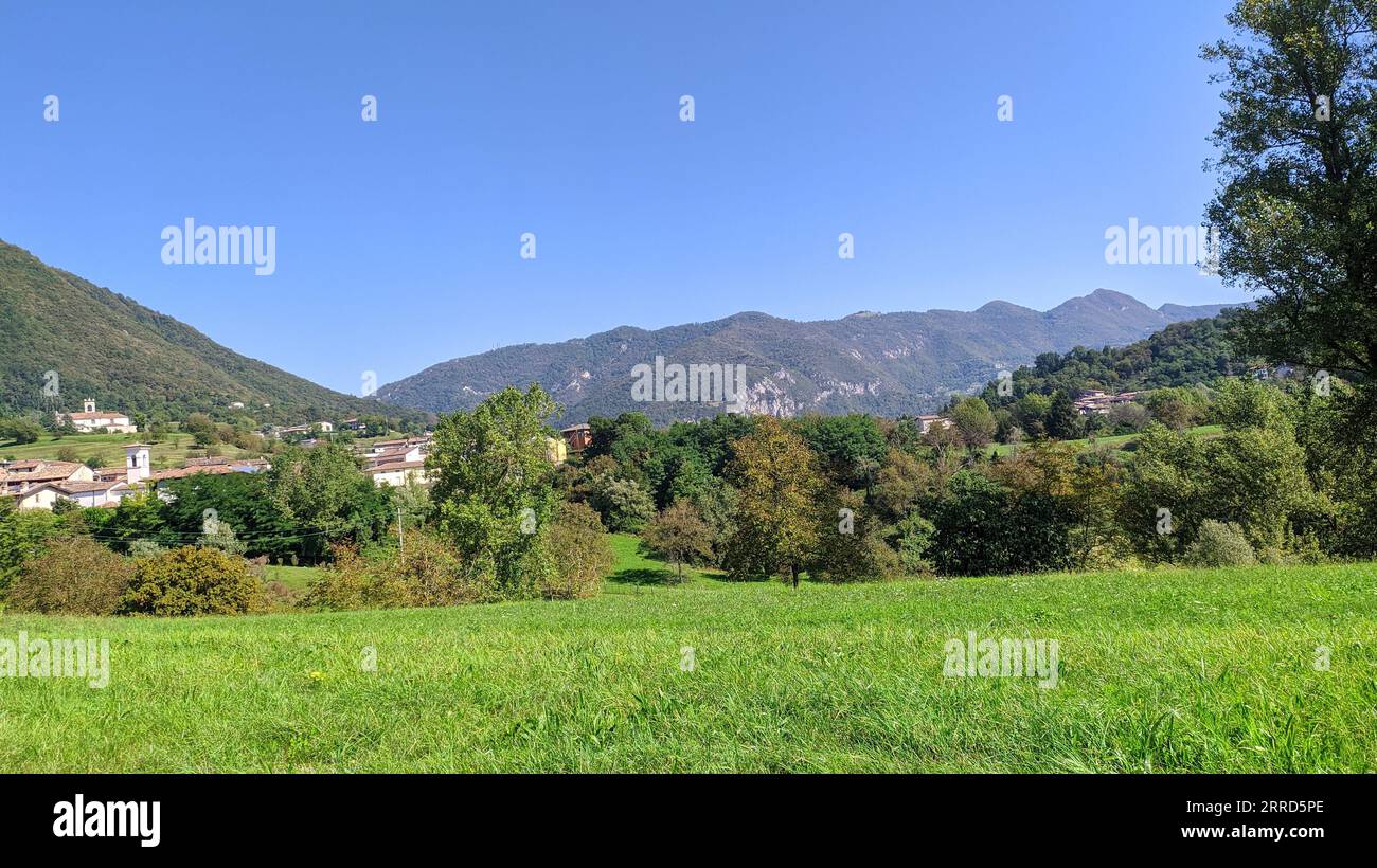 Vallée verte avec ville et montagnes Banque D'Images