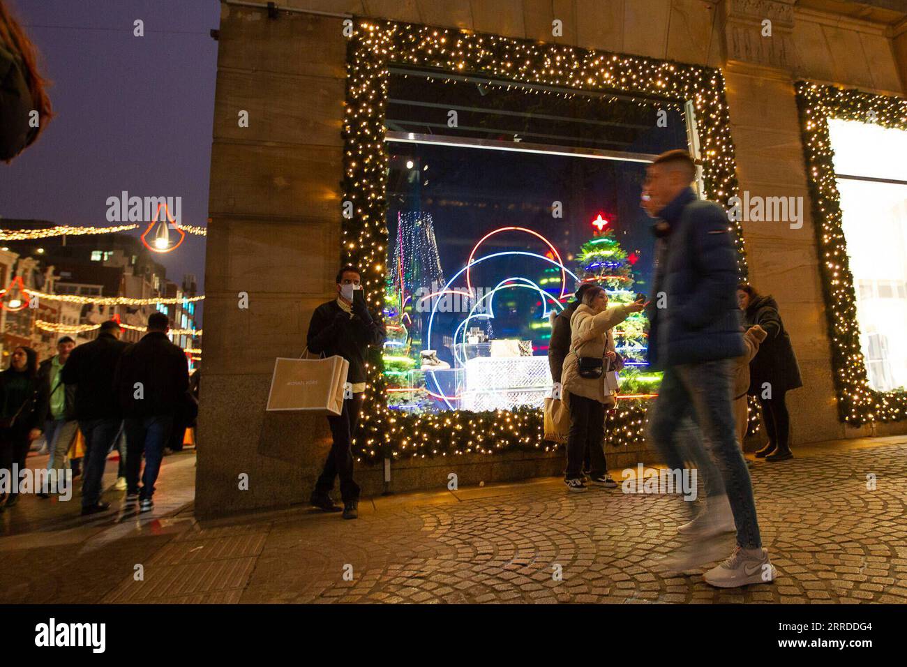 211218 -- AMSTERDAM, 18 décembre 2021 -- des gens marchent dans une rue ornée de décorations de Noël à Amsterdam, pays-Bas, le 18 décembre 2021. Le gouvernement néerlandais a annoncé un confinement plus strict samedi par crainte de la montée de la variante Omicron du COVID-19 dans le pays. Le nouveau confinement entrera en vigueur à partir de 5 h, dimanche matin, heure locale, et restera en vigueur jusqu’au 14 janvier 2022. Photo de /Xinhua PAYS-BAS-AMSTERDAM-NOËL-DÉCORATIONS SylviaxLederer PUBLICATIONxNOTxINxCHN Banque D'Images