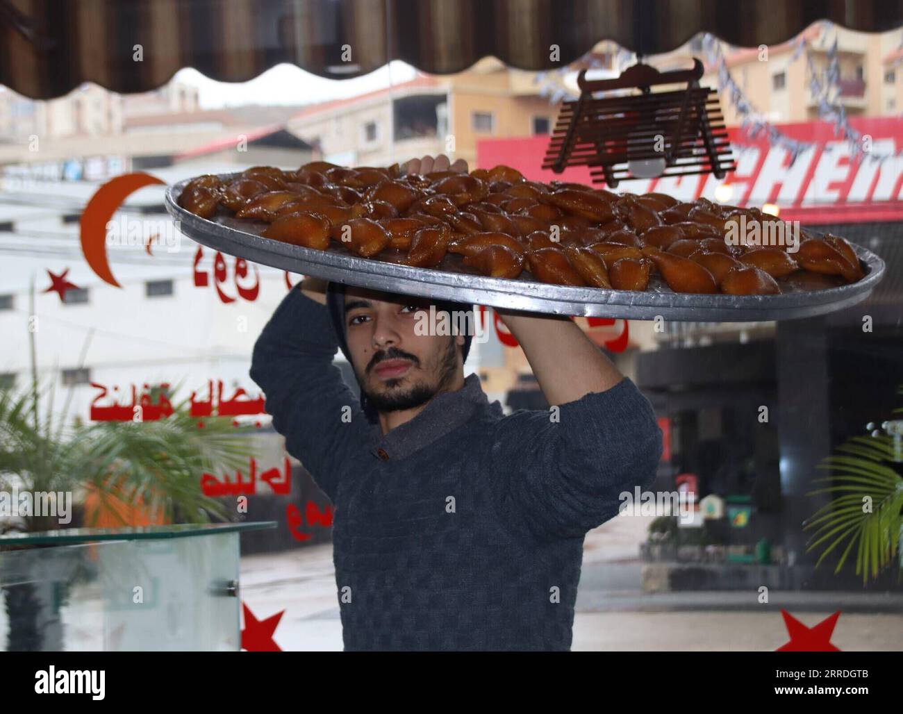 211225 -- NABATIYEH, 25 décembre 2021 -- un ouvrier transporte des bonbons à arranger dans un magasin de bonbons de la ville de Nabatiyeh, au Sud-Liban, le 22 décembre 2021. Les boutiques de bonbons voient leurs prix augmenter cette année à la lumière de la détérioration de la situation économique au Liban. Photo de /Xinhua LEBANON-NABATIYEH-FRIANDISES SHOP-PRICES TaherxAbuxHamdan PUBLICATIONxNOTxINxCHN Banque D'Images