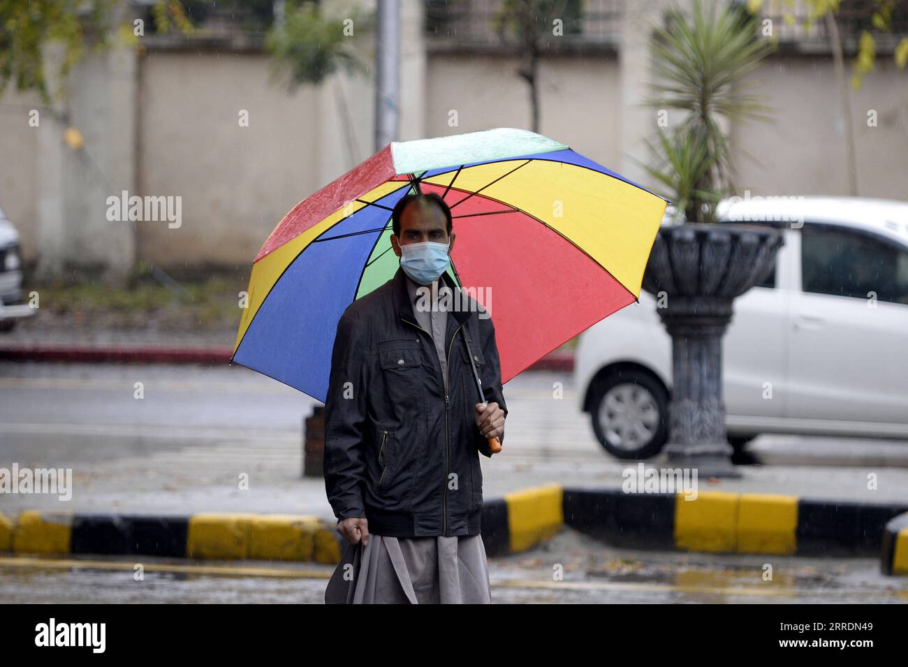 220104 -- ISLAMABAD, le 4 janvier 2022 -- Un homme marche sous la pluie sur une route à Islamabad, capitale du Pakistan, le 4 janvier 2022. PAKISTAN-ISLAMABAD-PLUIE-VIE QUOTIDIENNE AhmadxKamal PUBLICATIONxNOTxINxCHN Banque D'Images