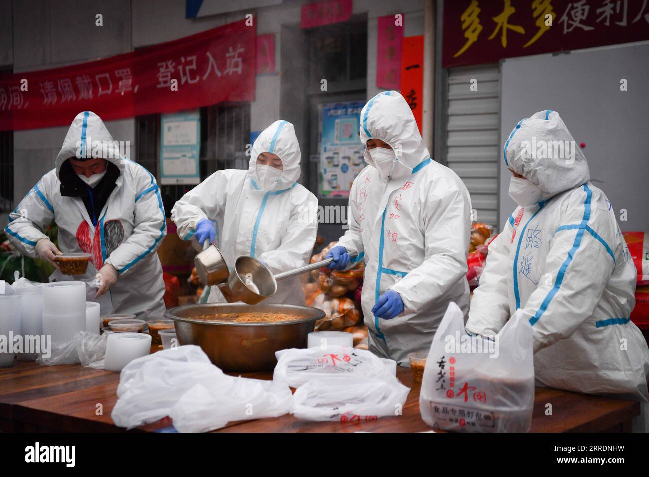 220105 -- XI AN, le 5 janvier 2022 -- des volontaires emballent des aliments pour livraison à la cuisine partagée Deshan dans le district de Yanta de Xi an, dans la province du Shaanxi au nord-ouest de la Chine, le 4 janvier 2022. Situé dans le district de Yanta de Xi an, la cuisine partagée Deshan a été gérée comme une cuisine anti-cancer , offrant la commodité pour les patients atteints de cancer et leurs familles pour cuisiner des repas. Xu Kai, fondateur de la cuisine partagée, a transformé cette cuisine anti-cancer en cuisine de lutte contre l’épidémie après que la ville ait été frappée par la récente résurgence du COVID-19. Jusqu'à présent, plus de 30 bénévoles se sont joints aux activités de livraison de nourriture de Banque D'Images