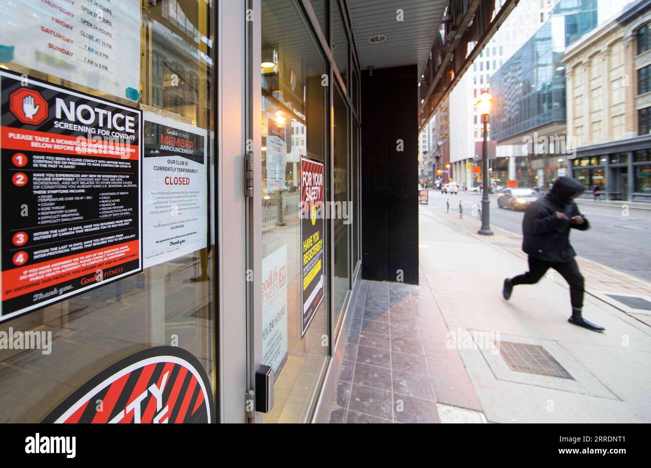 220105 -- TORONTO, le 5 janvier 2022 -- Un homme court devant un club de conditionnement physique fermé à Toronto, Ontario, Canada, le 5 janvier 2022. En réponse aux tendances récentes qui montrent une augmentation alarmante des hospitalisations liées à la COVID-19, le gouvernement de l’Ontario a commencé mercredi à imposer des mesures pour réduire la transmission du virus pendant au moins 21 jours, y compris la fermeture des gymnases, des théâtres, des cinémas, des musées, galeries et interdiction de manger à l'intérieur dans les restaurants. Photo de /Xinhua CANADA-ONTARIO-TORONTO-COVID-19-MESURES ZouxZheng PUBLICATIONxNOTxINxCHN Banque D'Images