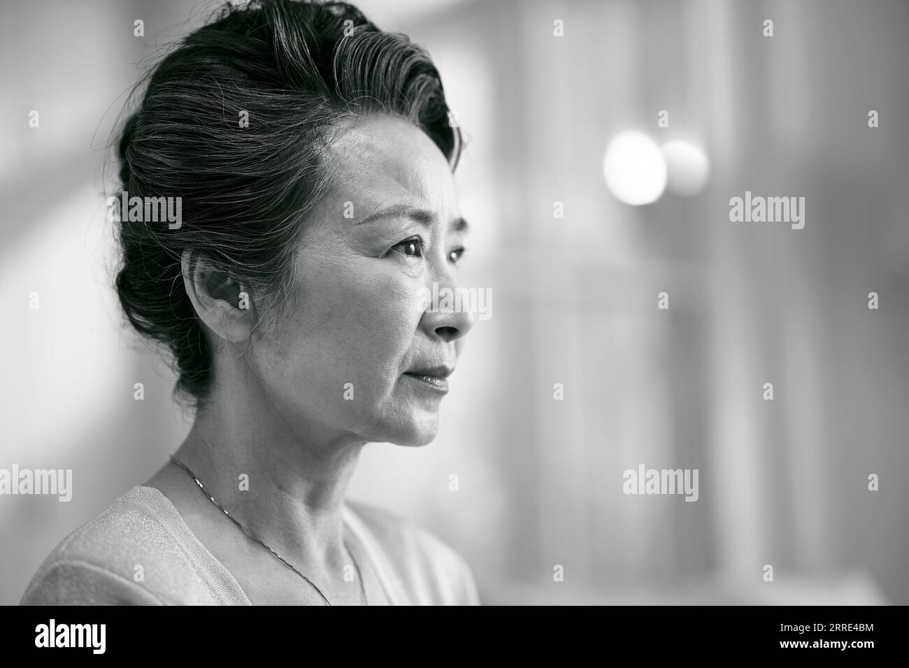 portrait de tête d'une vieille femme asiatique triste, vue de côté, noir et blanc Banque D'Images