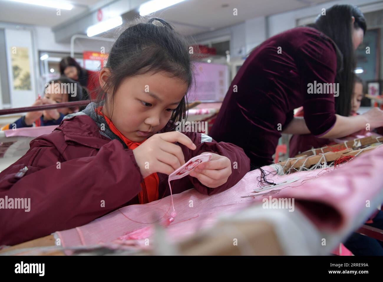 220211 -- NANCHANG, le 11 février 2022 -- Un enfant apprend à broder le motif de Bing Dwen Dwen, la mascotte des Jeux Olympiques d'hiver de Beijing 2022, dans le district de Donghu de la ville de Nanchang, dans la province de Jiangxi, dans l'est de la Chine, le 10 février 2022. CHINE-JIANGXI-NANCHANG-BING DWEN DWEN-BRODERIE CN PENGXZHAOZHI PUBLICATIONXNOTXINXCHN Banque D'Images