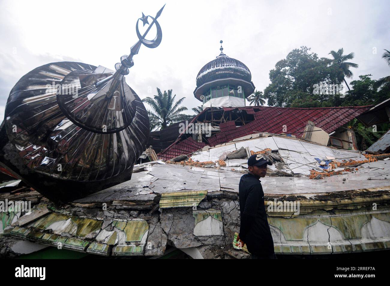 220225 -- SUMATRA OUEST, 25 février 2022 -- Un homme se tient près d'une maison endommagée après un tremblement de terre dans le village de Talamau, dans le district de Pasaman Barat, Sumatra Ouest, Indonésie, le 25 février 2022. Sept personnes ont été tuées et 85 autres blessées lorsqu'un tremblement de terre de magnitude 6,1 a détruit vendredi plus de 10 000 bâtiments, maisons et infrastructures dans la province occidentale de Sumatra ouest de l'Indonésie, a déclaré un haut responsable. Photo de /Xinhua INDONESIA-WEST SUMATRA-QUAKE-AFTERMATH ArdhyxFernando PUBLICATIONxNOTxINxCHN Banque D'Images