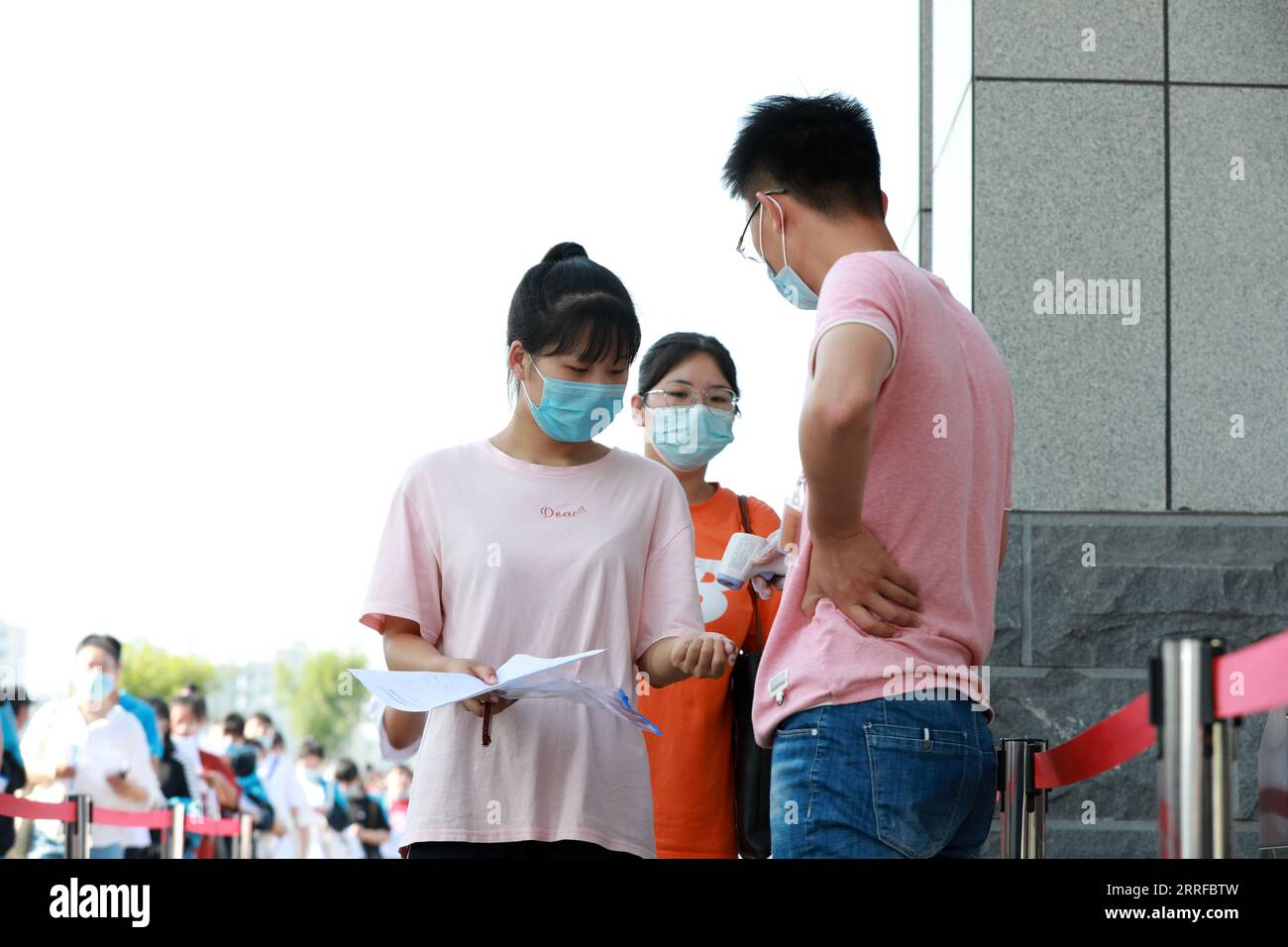 COMTÉ de LUANNAN, province du Hebei, Chine - 7 juillet 2020 : les candidats à l'entrée du collège entrent dans la salle d'examen après avoir reçu des tests de température corporelle, dans Banque D'Images