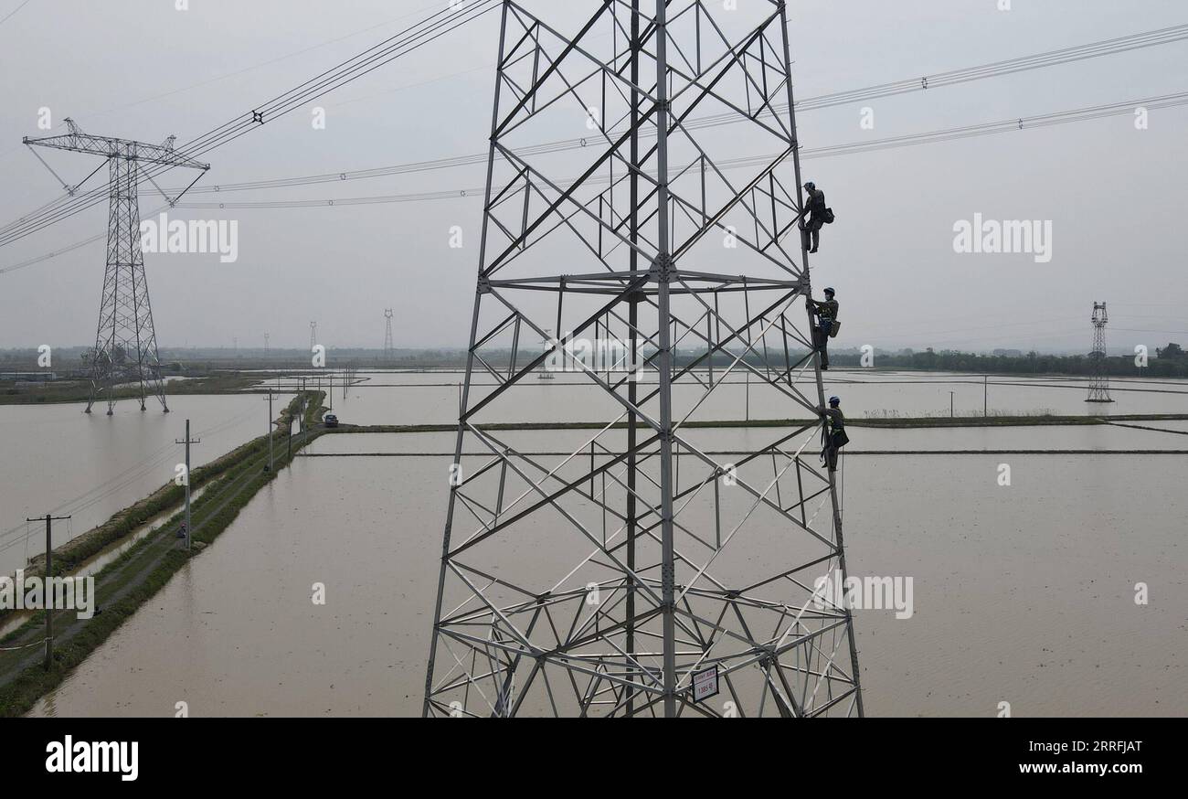 220419 -- HEFEI, le 19 avril 2022 -- une photo aérienne prise le 19 avril 2022 montre des travailleurs escaladant la tour de transmission d'énergie pour entretenir le projet de transmission de courant continu de 500 kilovolts de Longquan-Zhengping dans le comté de Lujiang de Hefei, dans l'est de la Chine de la province d'Anhui. À Lujiang, dans la province de l Anhui, dans l est de la Chine, une équipe de techniciens des services publics travaille comme des spidermen pour entretenir le projet de transport en courant continu de 500 kilovolts qui s étend de Longquan à Zhengping. La ligne électrique passant par Anhui est l'un des canaux clés transmettant plus de 10 milliards de kWh d'électricité par an, hydroélectricité entièrement propre, fr Banque D'Images