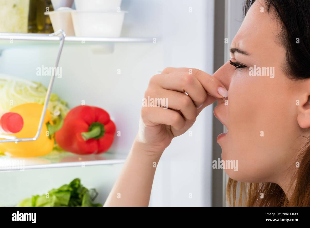 Une jeune femme a remarqué une odeur sortant du réfrigérateur Banque D'Images