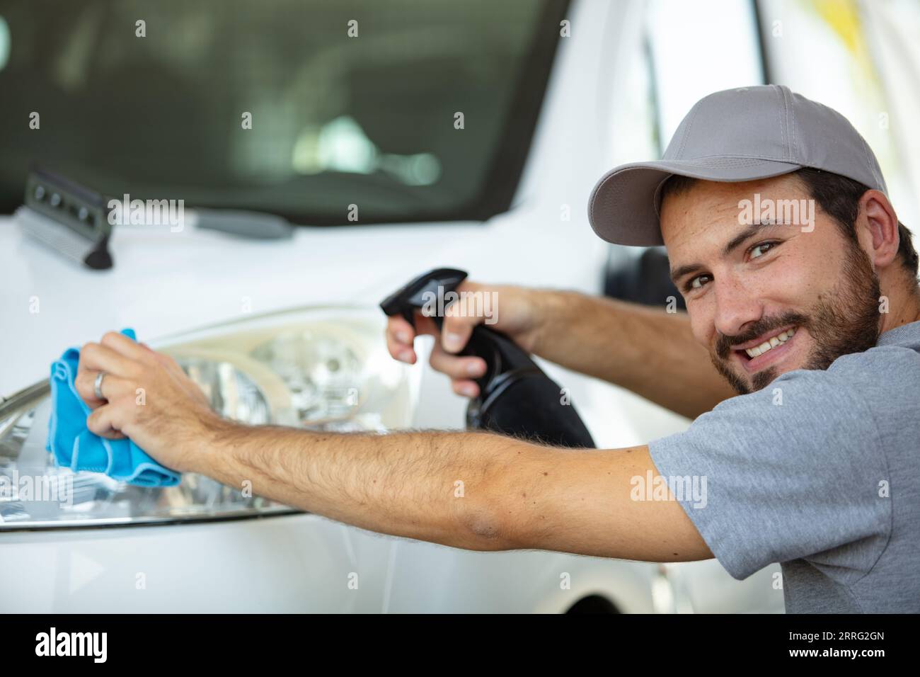 personnel de service automobile dans la voiture de nettoyage uniforme avec chiffon en microfibre Banque D'Images