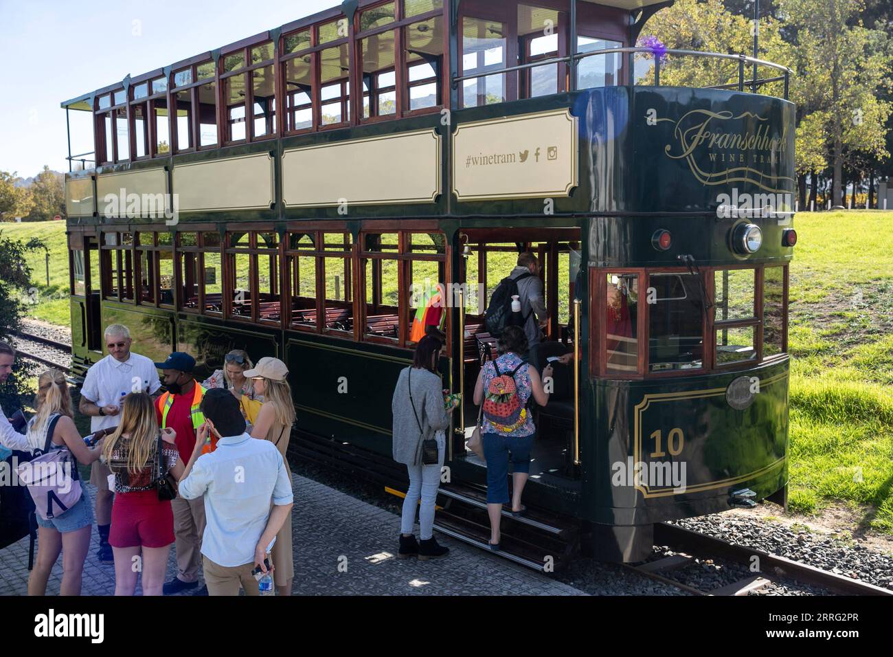 220505 -- FRANSCHHOEK, le 5 mai 2022 -- les touristes montent à bord d'un tramway viticole à Franschhoek, en Afrique du Sud, le 4 mai 2022. Le Franschhoek Wine Tram a huit lignes, emmenant les touristes à différents domaines viticoles dans la vallée de Franschhoek. Les pistes sur lesquelles circule maintenant le Franschhoek Wine Tram ont été construites à l'origine en 1904 pour servir d'alternative aux charrettes tirées par des bœufs pour les agriculteurs. Les tramways à deux étages sont inspirés d'un tramway datant d'environ 1923. AFRIQUE DU SUD-FRANSCHHOEK-VIN TRAM LyvxTianran PUBLICATIONxNOTxINxCHN Banque D'Images