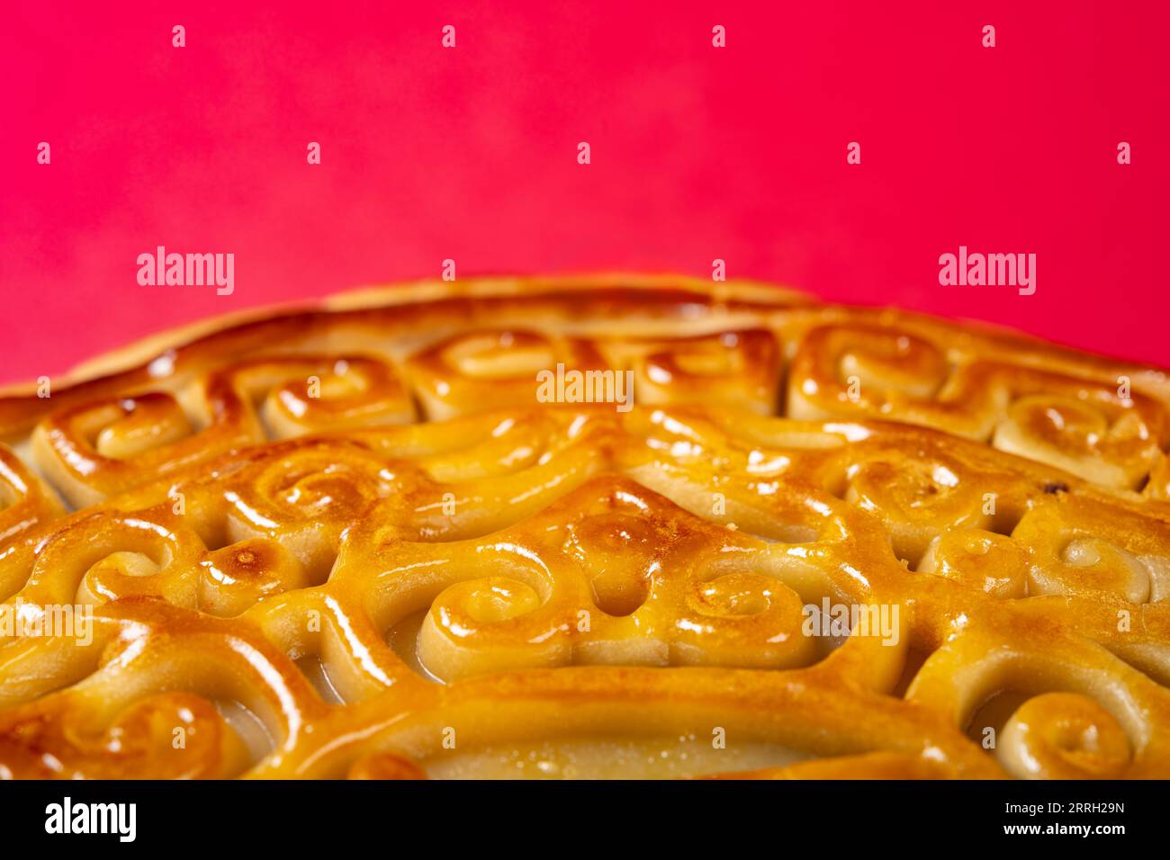 Partie d'un gâteau de lune chinois traditionnel sur rouge avec la composition horizontale de l'espace de copie Banque D'Images