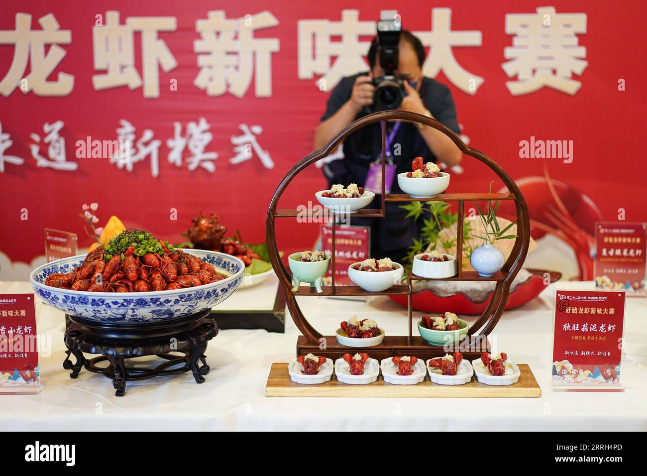 220612 -- NANJING, le 12 juin 2022 -- Un journaliste prend des photos de plats d'écrevisses présentés lors d'un festival international d'écrevisses dans le comté de Xuyi de Huai an, province du Jiangsu, dans l'est de la Chine, le 12 juin 2022. Un festival international d'écrevisses a débuté dimanche dans le comté de Xuyi, une importante base d'écrevisses dans la province de Jiangsu, dans l'est de la Chine, offrant un festin pour les fans d'écrevisses. Le comté, avec une zone d'élevage d'écrevisses de 835 000 mu environ 55 667 hectares, voit plus de 200 000 personnes engagées dans des entreprises liées aux écrevisses. CHINA-JIANGSU-XUYI-INT L ÉCREVISSE FESTIVAL CN JIXCHUNPENG PUBLICATIONXNOTXINXCHN Banque D'Images