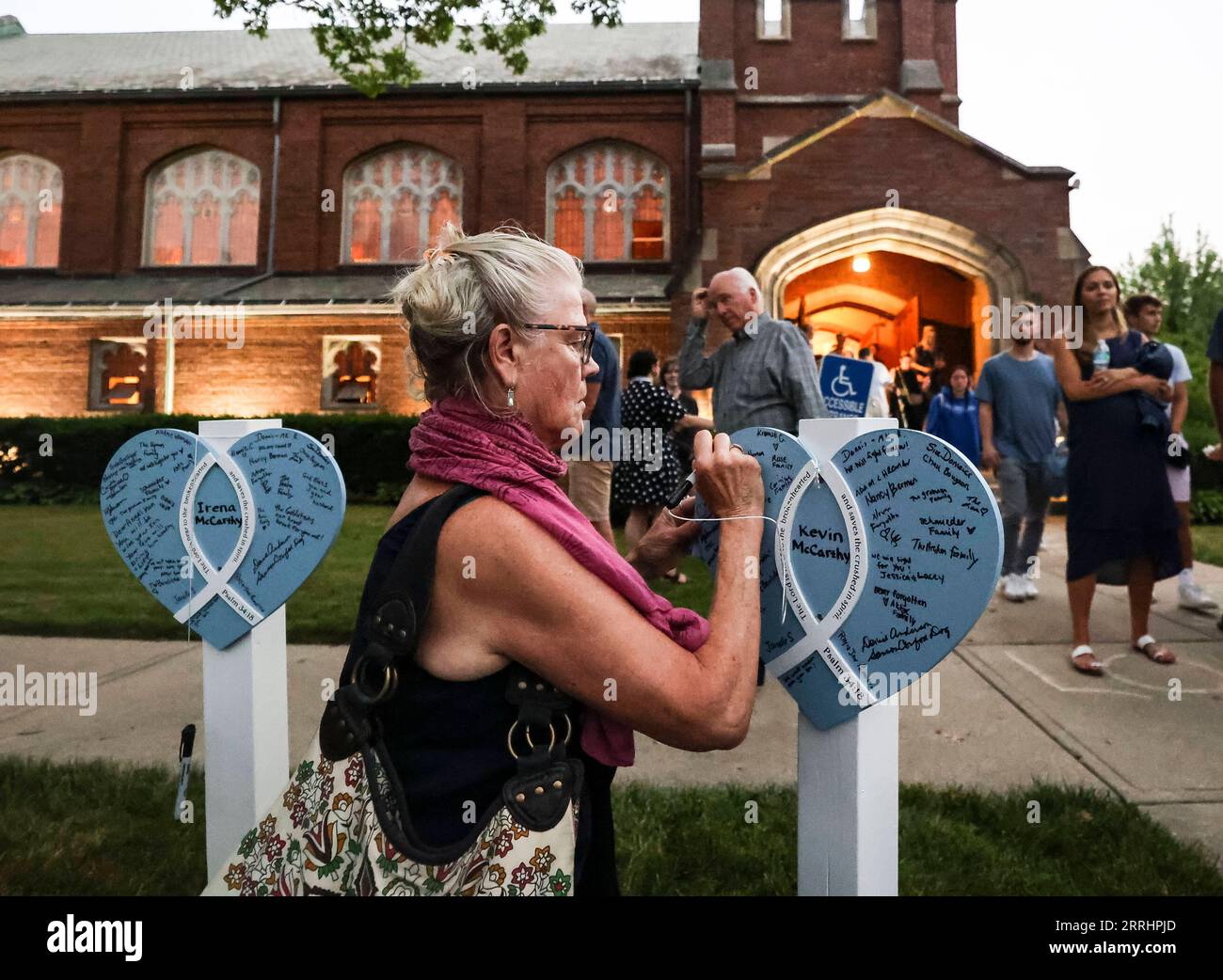 220706 -- HIGHLAND PARK, le 6 juillet 2022 -- Une femme laisse un message sur un panneau en forme de cœur honorant la victime Kevin McCarthy après une veillée de prière à Highland Park, banlieue de Chicago, Illinois, États-Unis, le 5 juillet 2022. des personnes ont célébré le deuil pour une fusillade de masse lors d ' un défilé du jour de l ' indépendance dans le centre-ville de Highland Park le 4 juillet. Le nombre de morts de la fusillade de masse est passé à sept, alors que la police a actualisé le nombre de blessés à 46. Photo de /Xinhua U.S.-HIGHLAND PARK-FUSILLADES MASSIVES DE VICTIMES-DEUIL JoelxLerner PUBLICATIONxNOTxINxCHN Banque D'Images