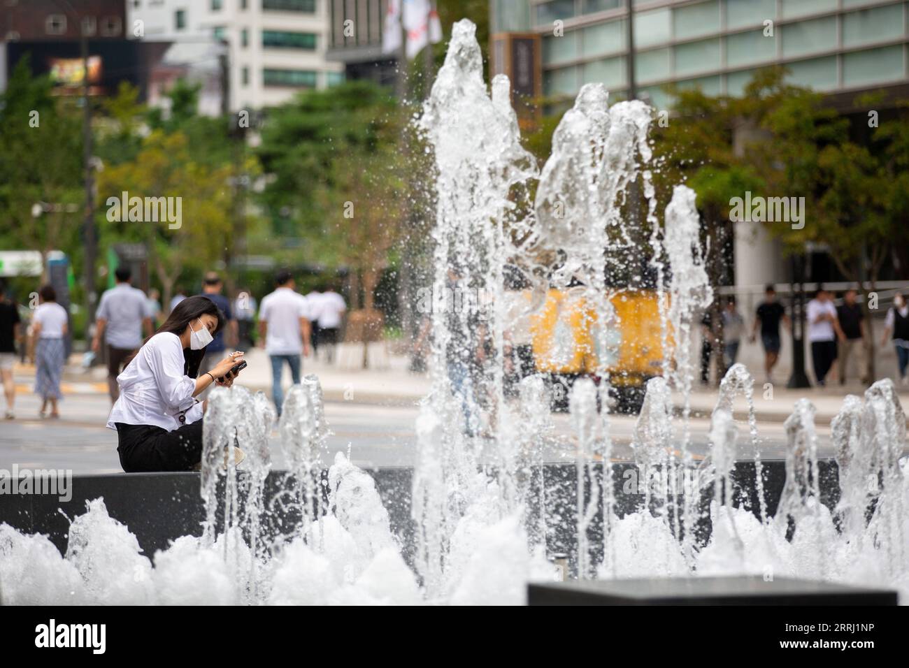 220712 -- SÉOUL, le 12 juillet 2022 -- Une femme portant un masque facial est assise près d'une source sur la place Cheonggyecheon à Séoul, en Corée du Sud, le 12 juillet 2022. La Corée du Sud a signalé 37 360 nouveaux cas de COVID-19 à minuit lundi par rapport à il y a 24 heures, portant le nombre total d’infections à 18 561 861, ont déclaré mardi les autorités sanitaires. CORÉE DU SUD-SÉOUL-COVID-19-CAS WangxYiliang PUBLICATIONxNOTxINxCHN Banque D'Images