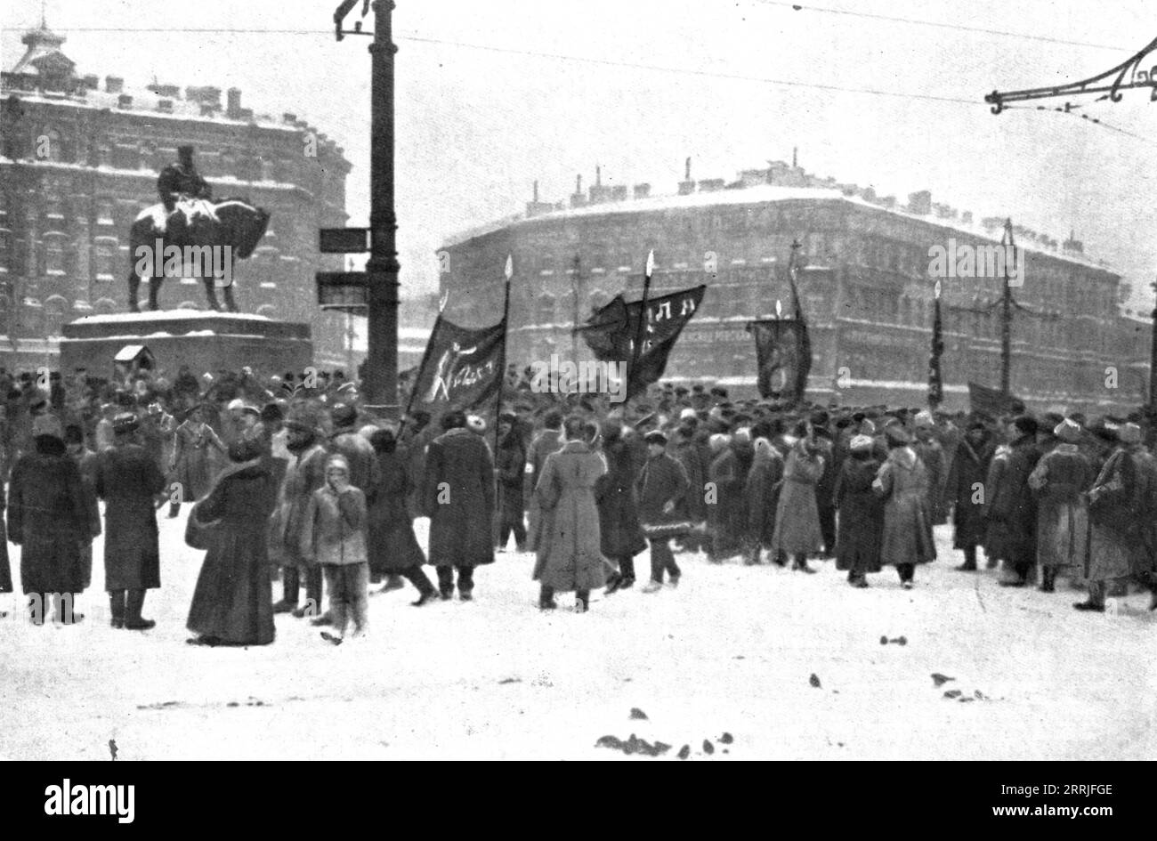 « La Revolution russe ; les premières manifestations sur la place Znamenskaia, a Petrograd, devant le monument d'Alexandre III ; deja, les rideaux rouges portent des images et des inscriptions révolutionnaires », 1917. La révolution russe : manifestations sur la place Znamenskaya, Petrograd, devant la statue d'Alexandre III, drapeaux rouges avec des slogans révolutionnaires. Extrait de "l'Album de la Guerre 1914-1919, Volume 2" [l'Illustration, Paris, 1924]. Banque D'Images