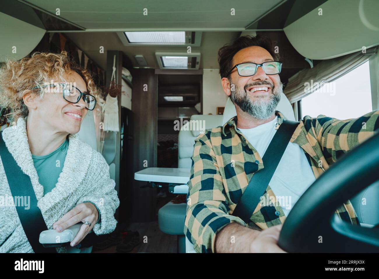 Heureux vanlife tourisme Lifestyle personnes conduisant et profitant de vacances ensemble à l'intérieur d'un camping-car dans la vue intérieure avant. Bonheur et liberté concept Lifestyle couple. Homme et femme utilisant le camping-car Banque D'Images